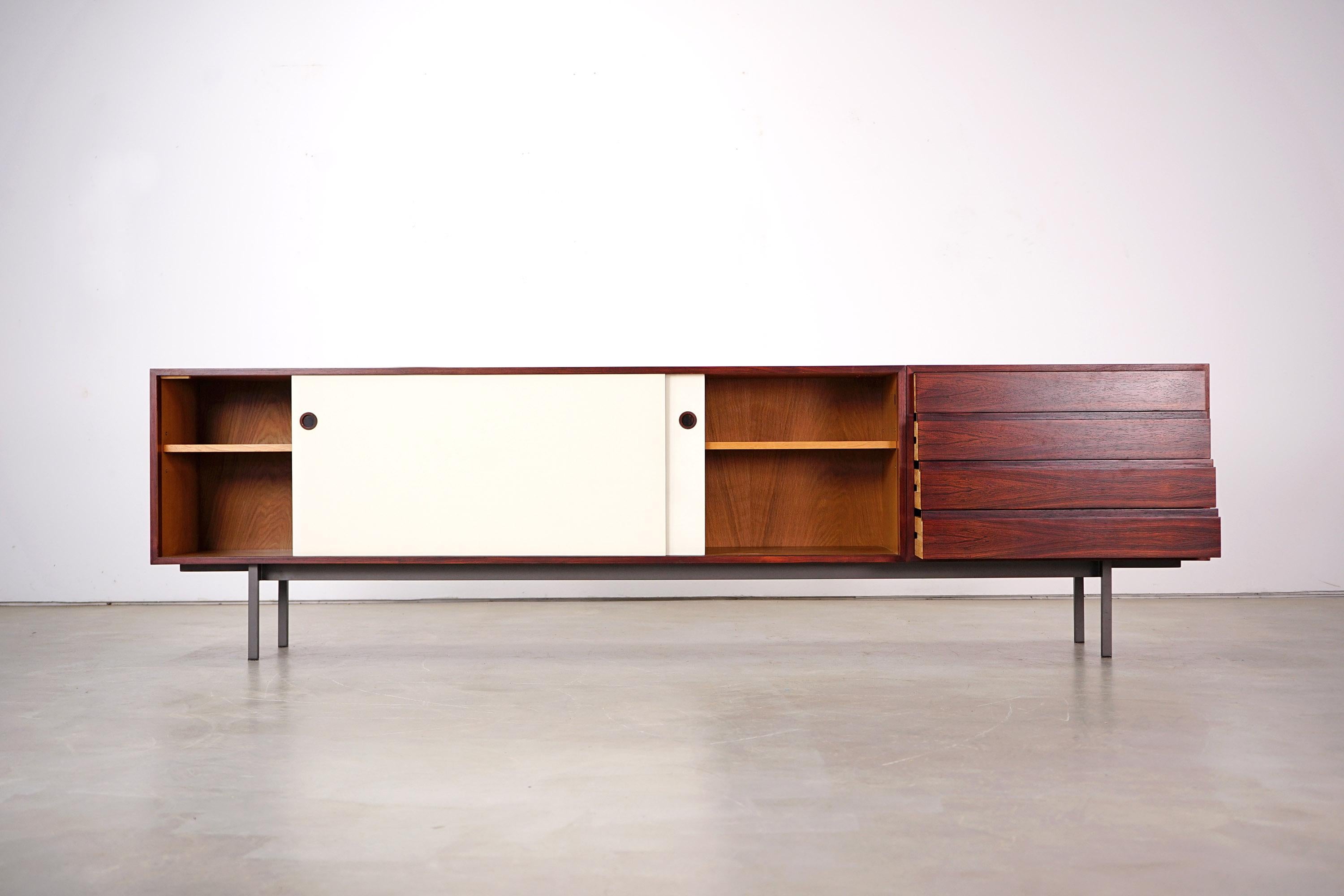 This spacious sideboard was designed by Walter Wirz and manufactured by Wilhelm Renz in Germany in the 1960s. It has a steel frame, beautiful texture and reversible sliding doors either made of wood or coated with Formica. One of the four existing