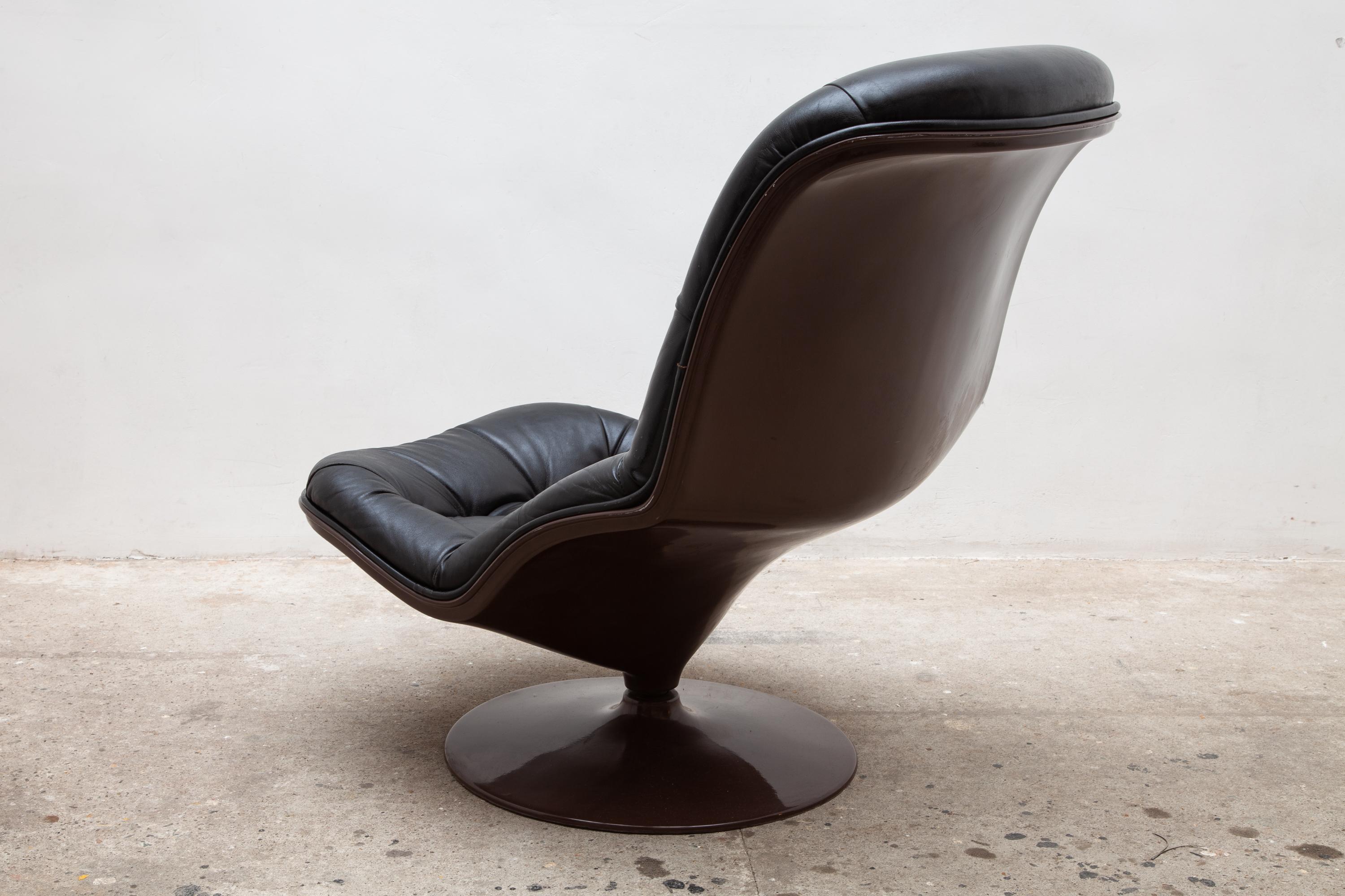 Stylish 1970s lounge seat was produced by Beaufort in Belgium. Tufted black leather on a chocolate brown fiberglass base. It has a swivel and tilt function. The chair is in pristine condition. Dimension: 70 W x 80 H x 70 D cm.
 