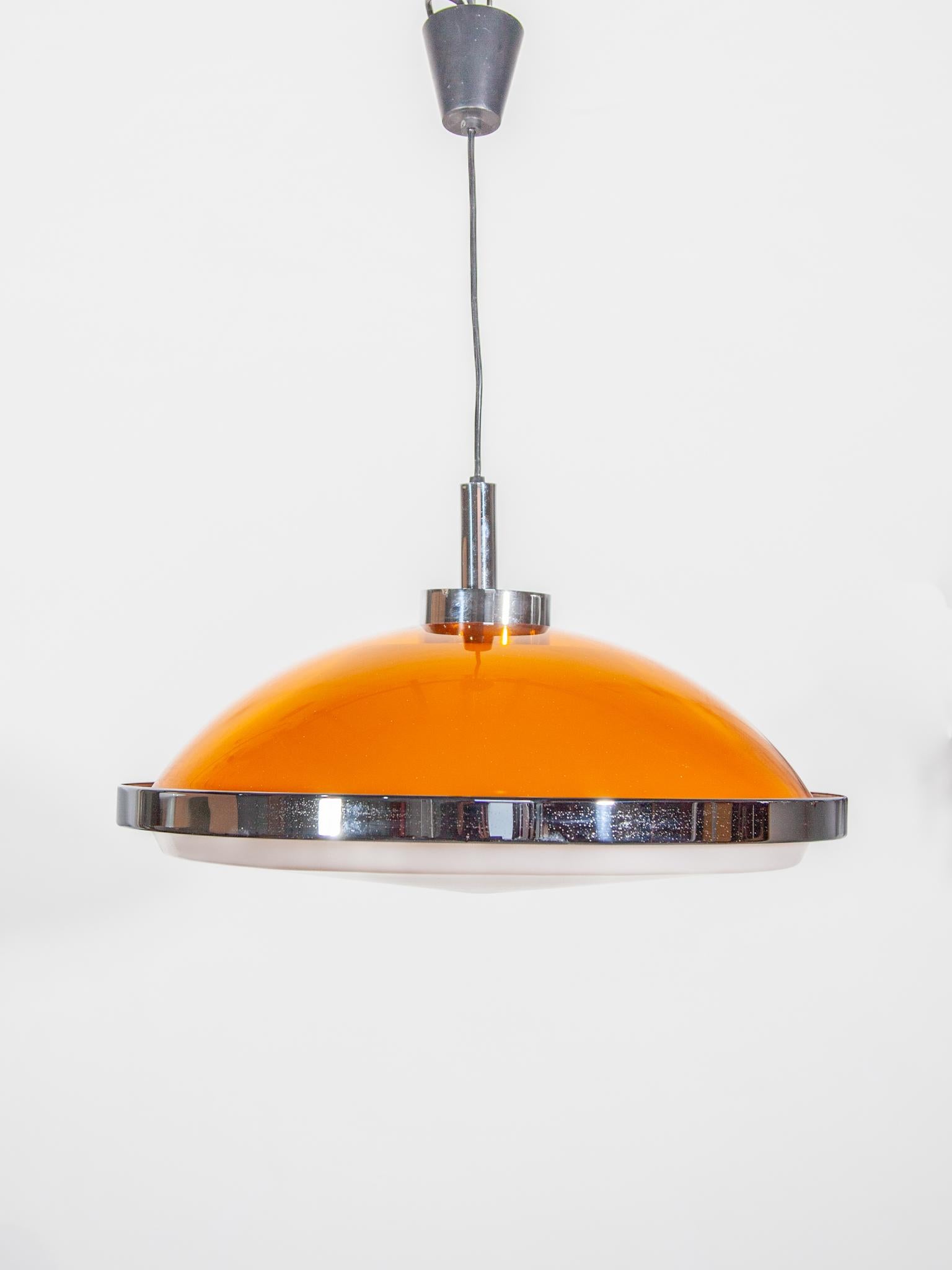 Very rare vintage pendant lamp designed in the space age seventies. This amazing vintage light is made of orange plastic with chrome. It gives a beautiful soft and warm light when it lit on. It's retro atomic looks, and beautiful ambient light are
