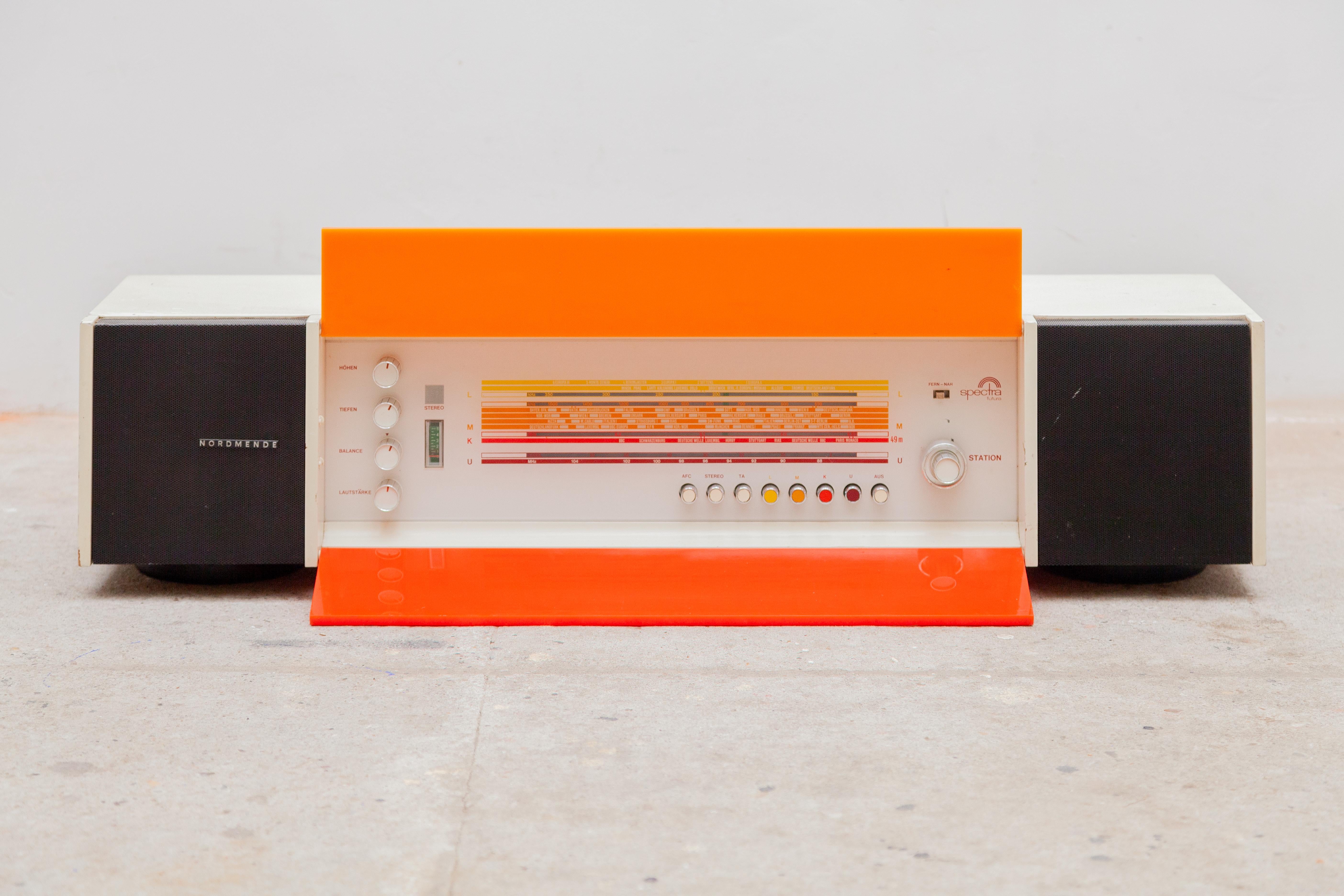 Original Pop Art Radio in good condition designed by the industrial designer Raymond Loewy.Radio with a plexi front, characteristic of Loewy in the colors red and orange, also recurring in his designed furniture.The plexi plates can be opened to