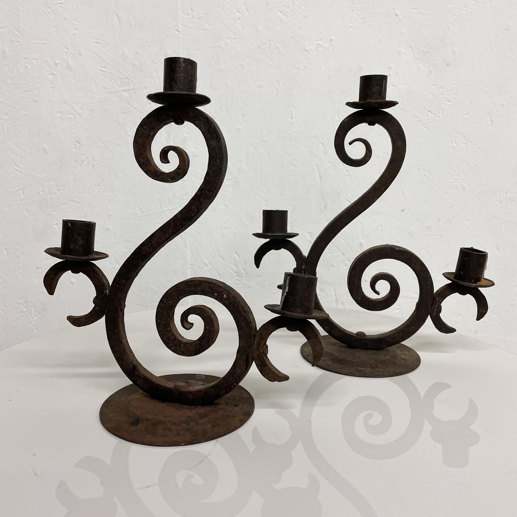 Vintage rustic forged pretty scroll Spanish iron three arm candle holders each candelabra
Set of two candelabras circa 1940s Spanish Colonial
Measures: 11.88 height x 10 width x 5 in diameter
Original unrestored vintage condition.
See images.

