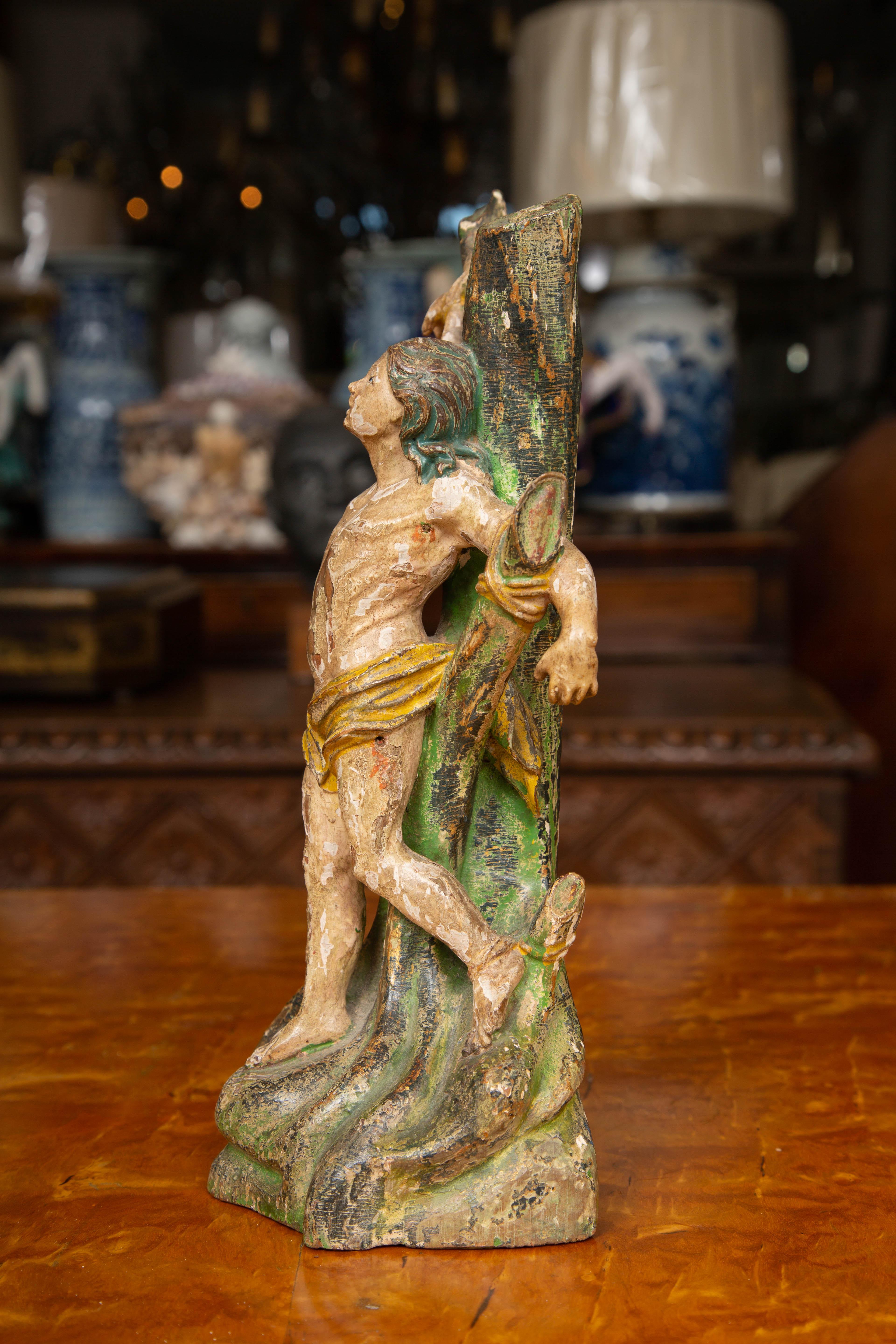 Dies ist eine klassische handgeschnitzte Figur des heiligen Sabastian, der während einer versuchten Verfolgung an einen Baum gefesselt ist. Er soll von der heiligen Irene von Rom gerettet und geheilt worden sein. Er wird sowohl in der