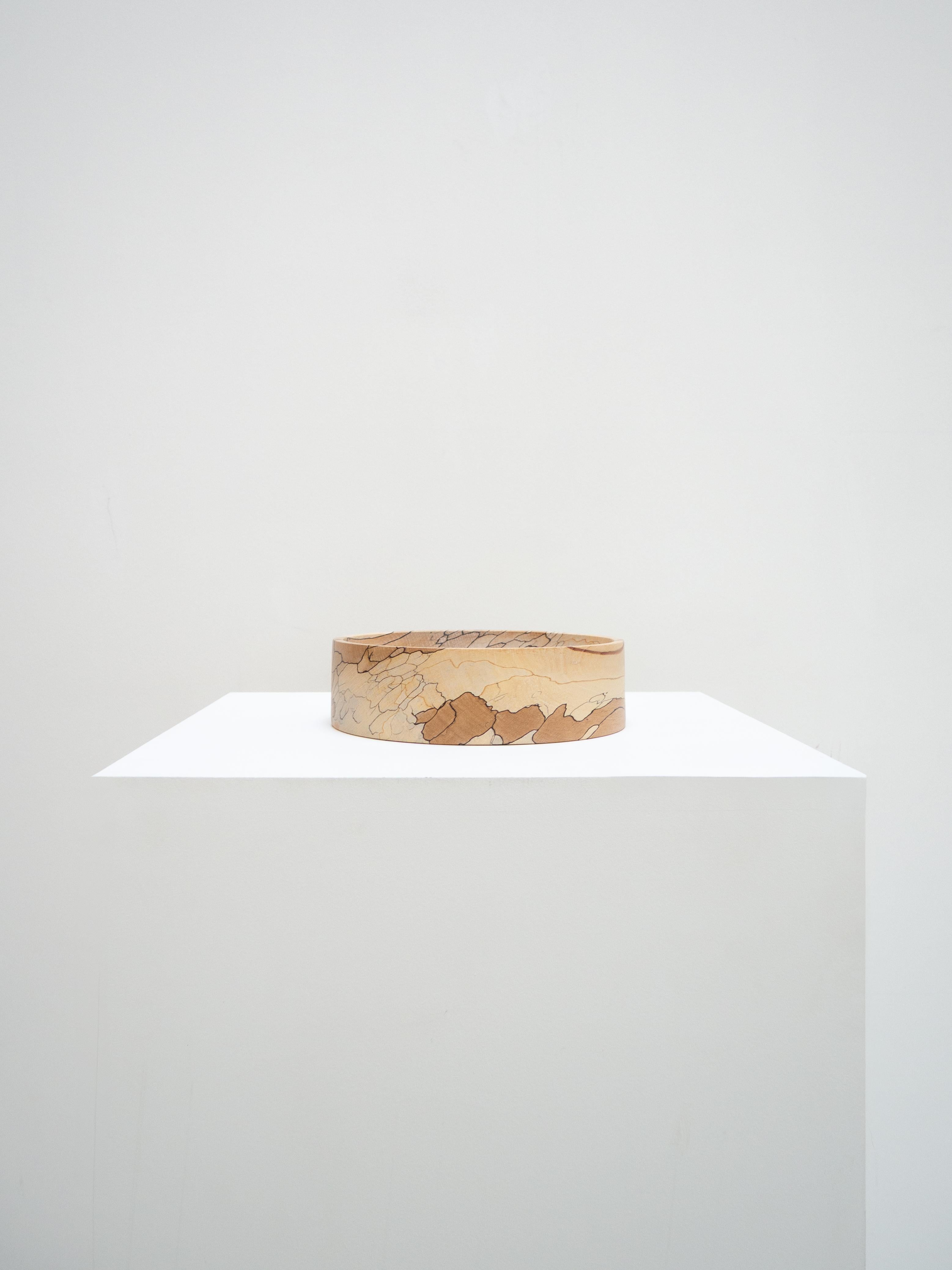 This beech bowl was turned by the English workshop Bird and Branch. Its straight profile and curved interior were designed to enhance the unique patterns of the heated wood, a rare material resulting from a long natural transformation process. A