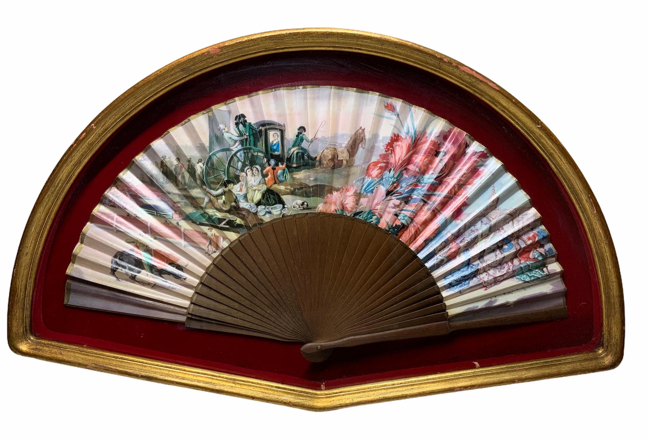 This is a wood sticks and handpainted Spaniard fan. It depicts four different scenes related to Spain. Starting in the left, there is a bullfighter fighting a bull in a bullring; then an 18th Century scene of a horse carriage with a lady inside it