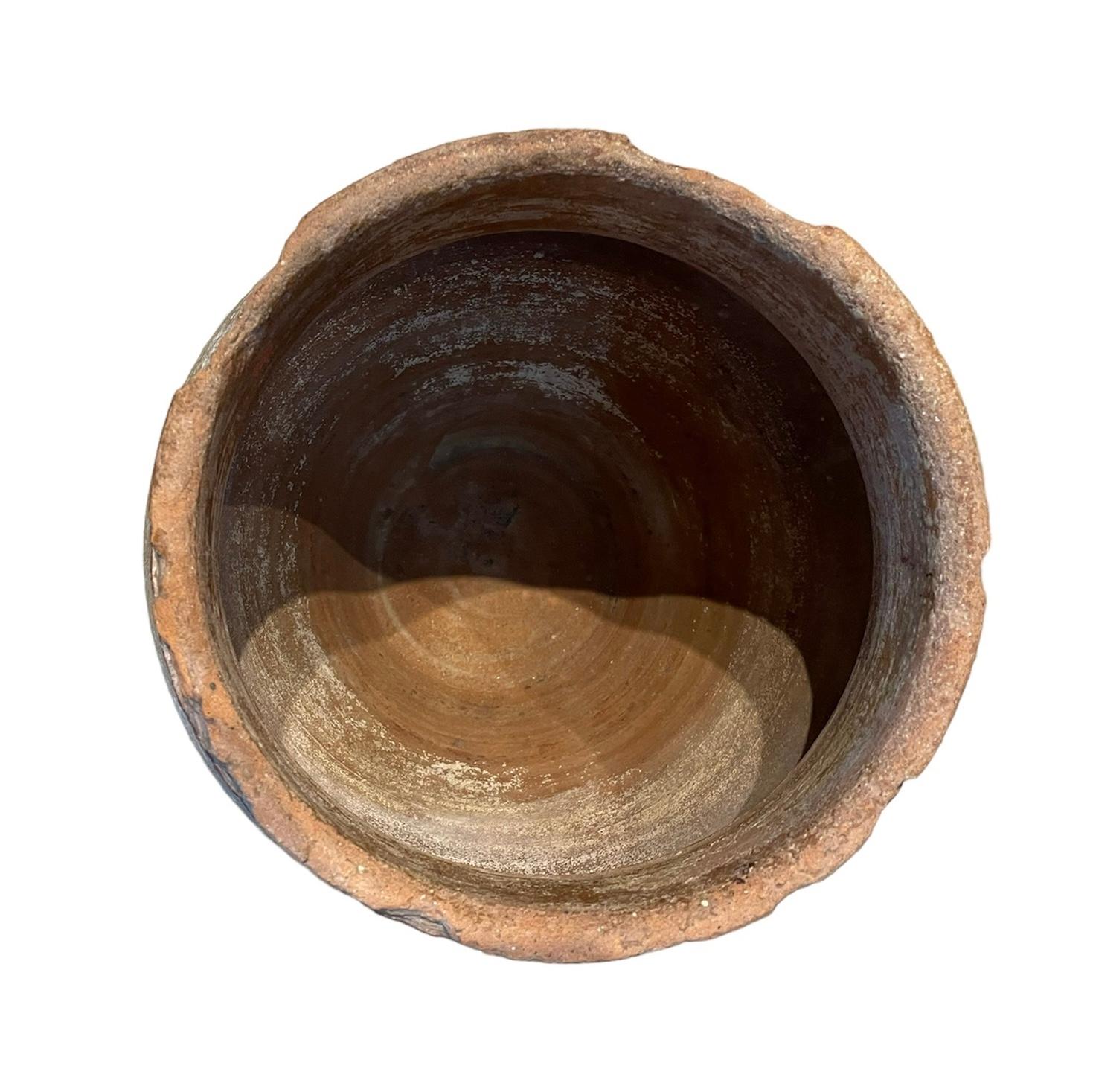 Il s'agit d'une petite amphore espagnole en terre cuite du 19e siècle. Elle représente une amphore large de couleur brique, ornée de volants comme dans sa bordure supérieure. Les amphores sont utilisées pour stocker et transporter de l'eau, du vin