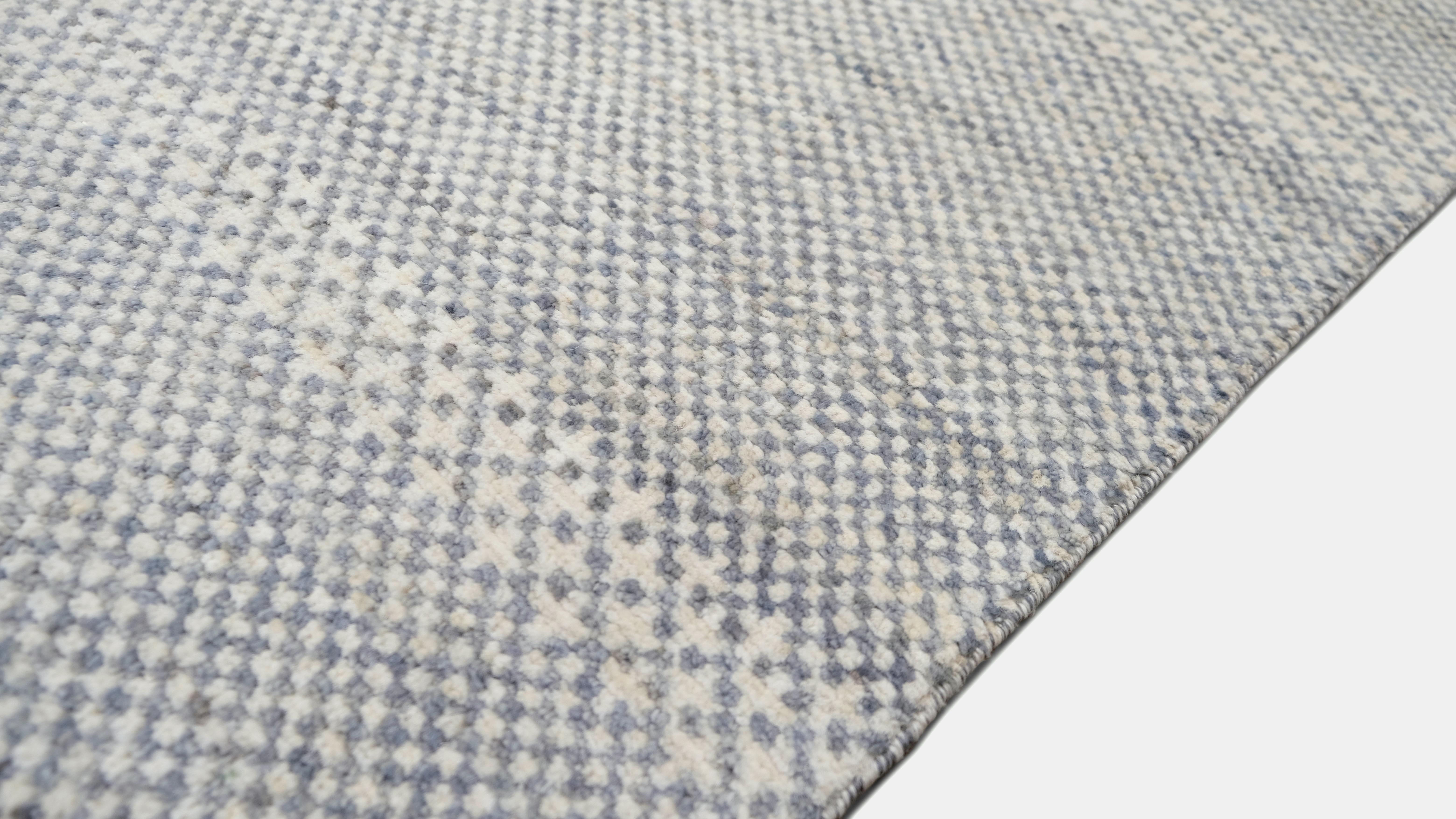Dieser handgeknüpfte Wollteppich in modernem, minimalistischem Design mit subtilen horizontalen Streifen wertet Ihre Einrichtung auf. Die sanften Blau- und Elfenbeintöne gehen nahtlos ineinander über und schaffen eine ruhige und raffinierte
