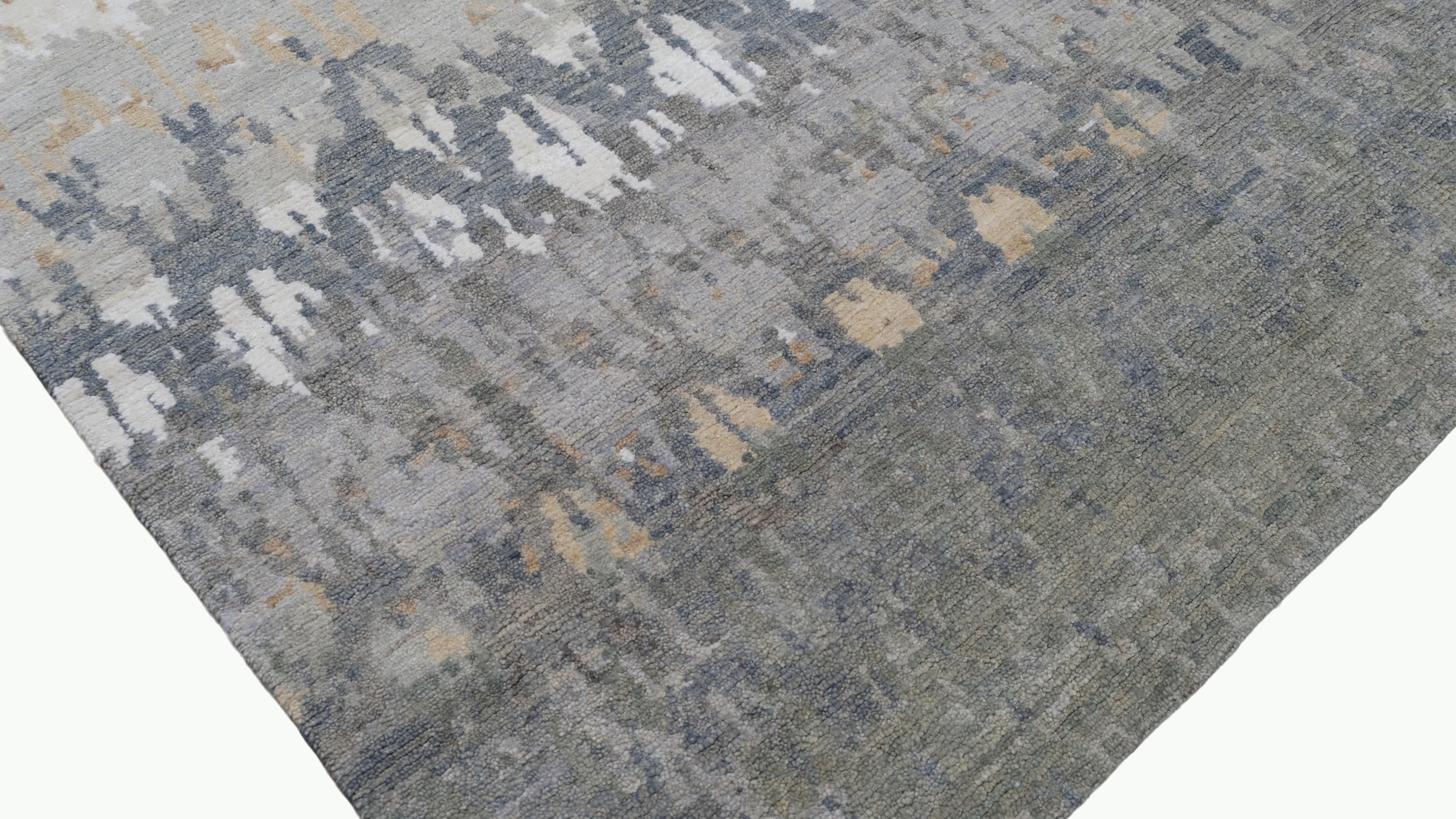 Rehaussez votre décoration intérieure avec ce tapis en laine nouée à la main, doté d'un superbe motif dégradé dans des tons de vert, d'or, de blanc et de gris. Le motif complexe s'étend parfaitement sur le tapis, créant un équilibre harmonieux entre