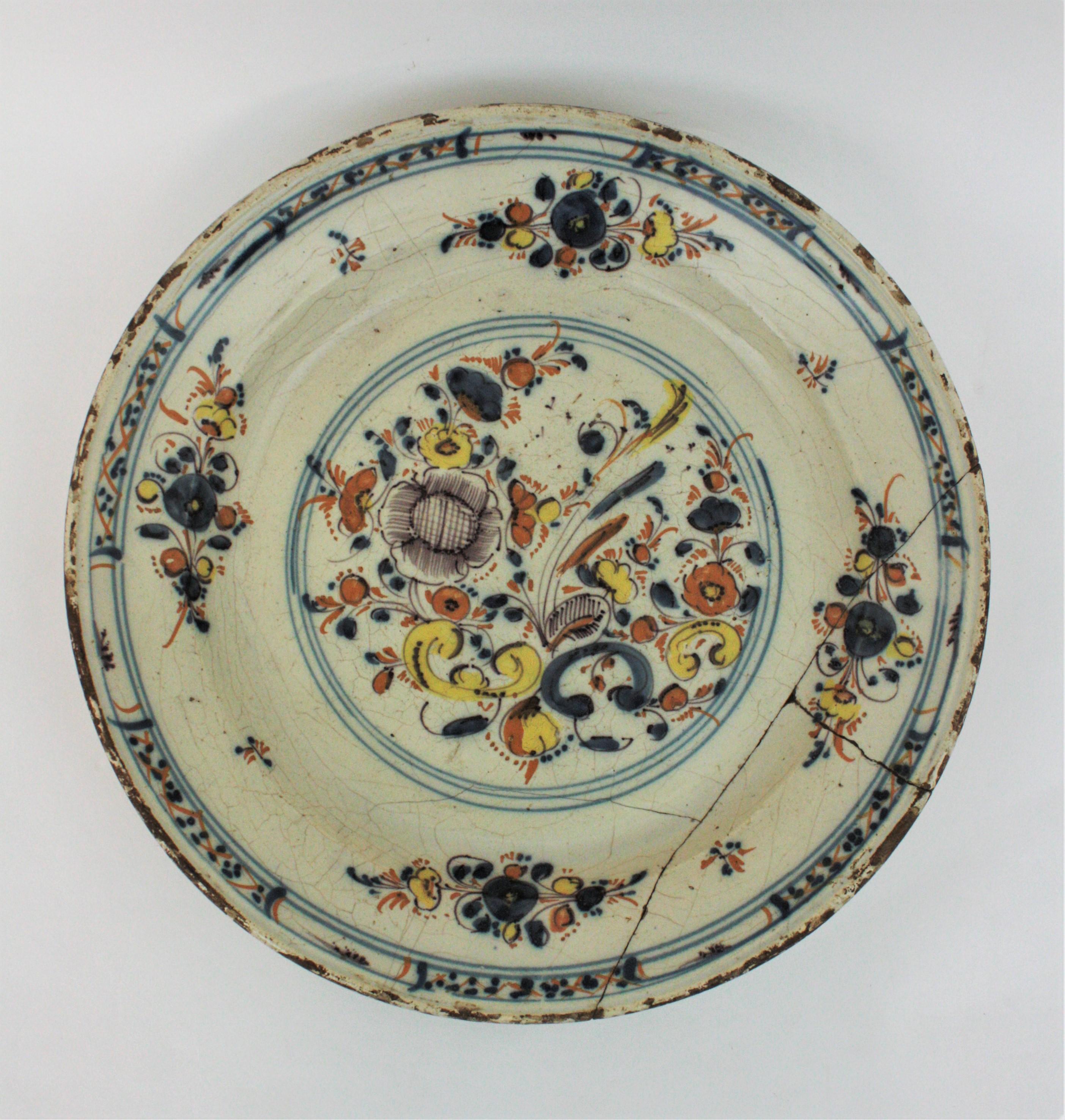 Spanish Faience charger with floral motifs. Talavera de la Reina-Puente del Arzobispo, Toledo. Spain, late 17th century.
Hand painted in ochre, yellow, brown and blue with a central roundel with a floral bouquet. Four smaller bouquets with stylised