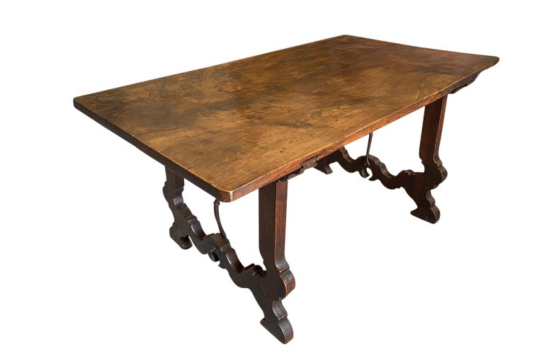 A very handsome 17th century writing table from the Catalan region of Spain. Beautifully constructed from stunning walnut and hand forged iron stretchers with classically shaped lyre legs and an outstanding solid board top. Excellent patina.