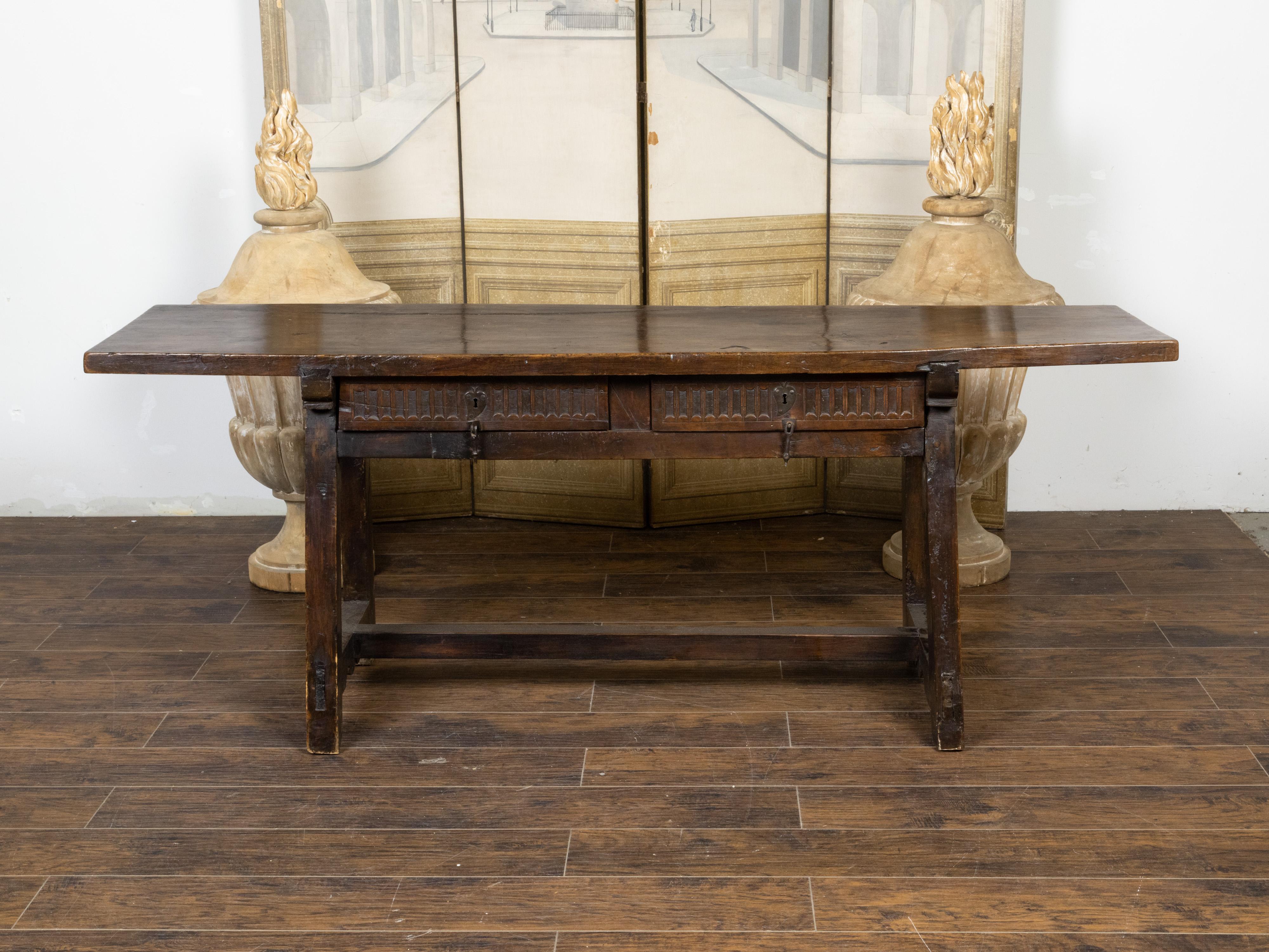 A Spanish wooden refectoire table from the early 19th century, with two drawers, fluted accents, A-Frame trestle base and great character. Created in Spain during the early years of the 19th century, this refectoire table could be used as a console