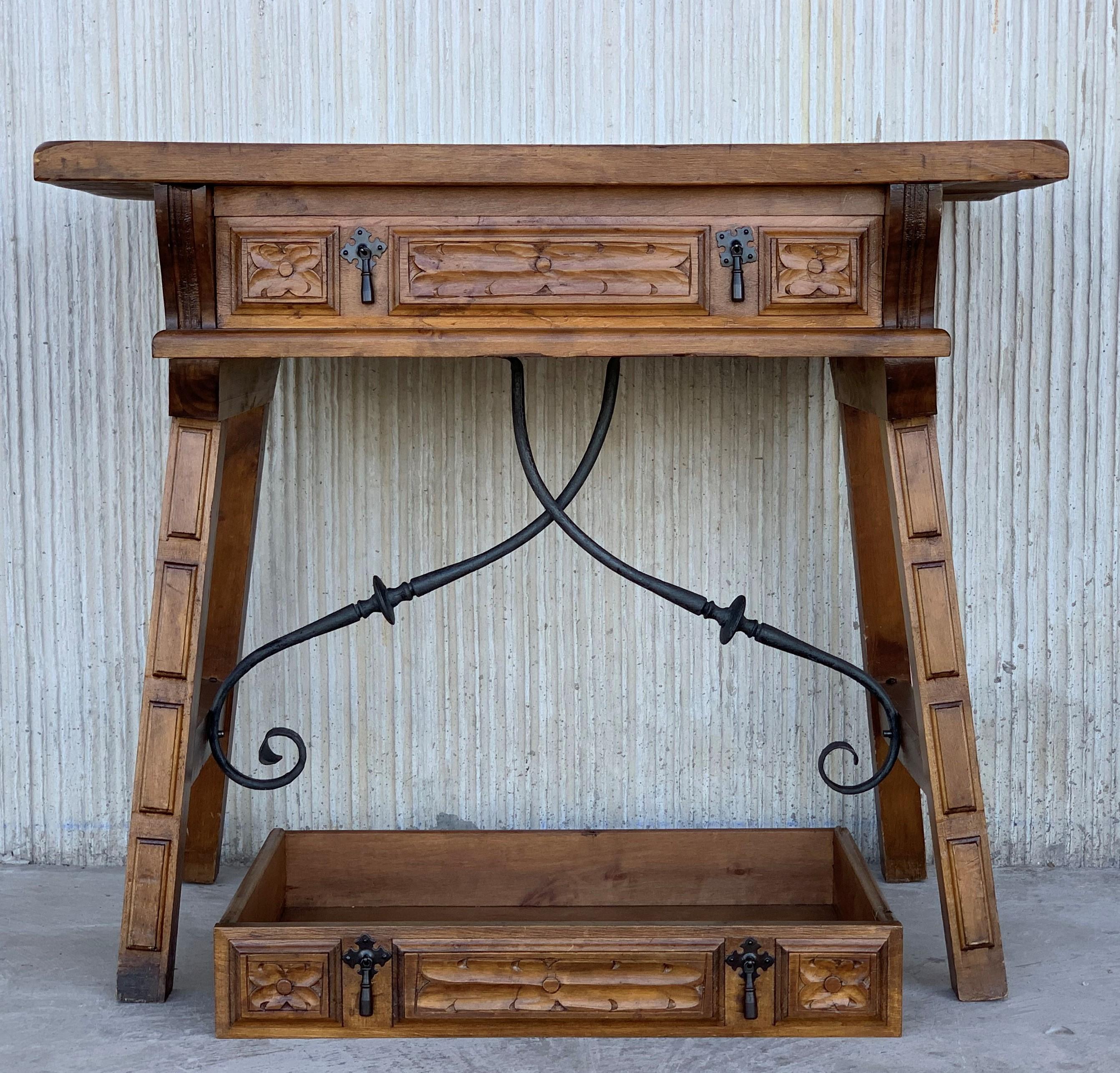 A Spanish walnut side table with single drawer, scalloped apron, carved legs and iron side stretcher from the late 19th century. 
The front it´s the same that the back, you can see in picture 2. 
This elegant Spanish table features a simple,