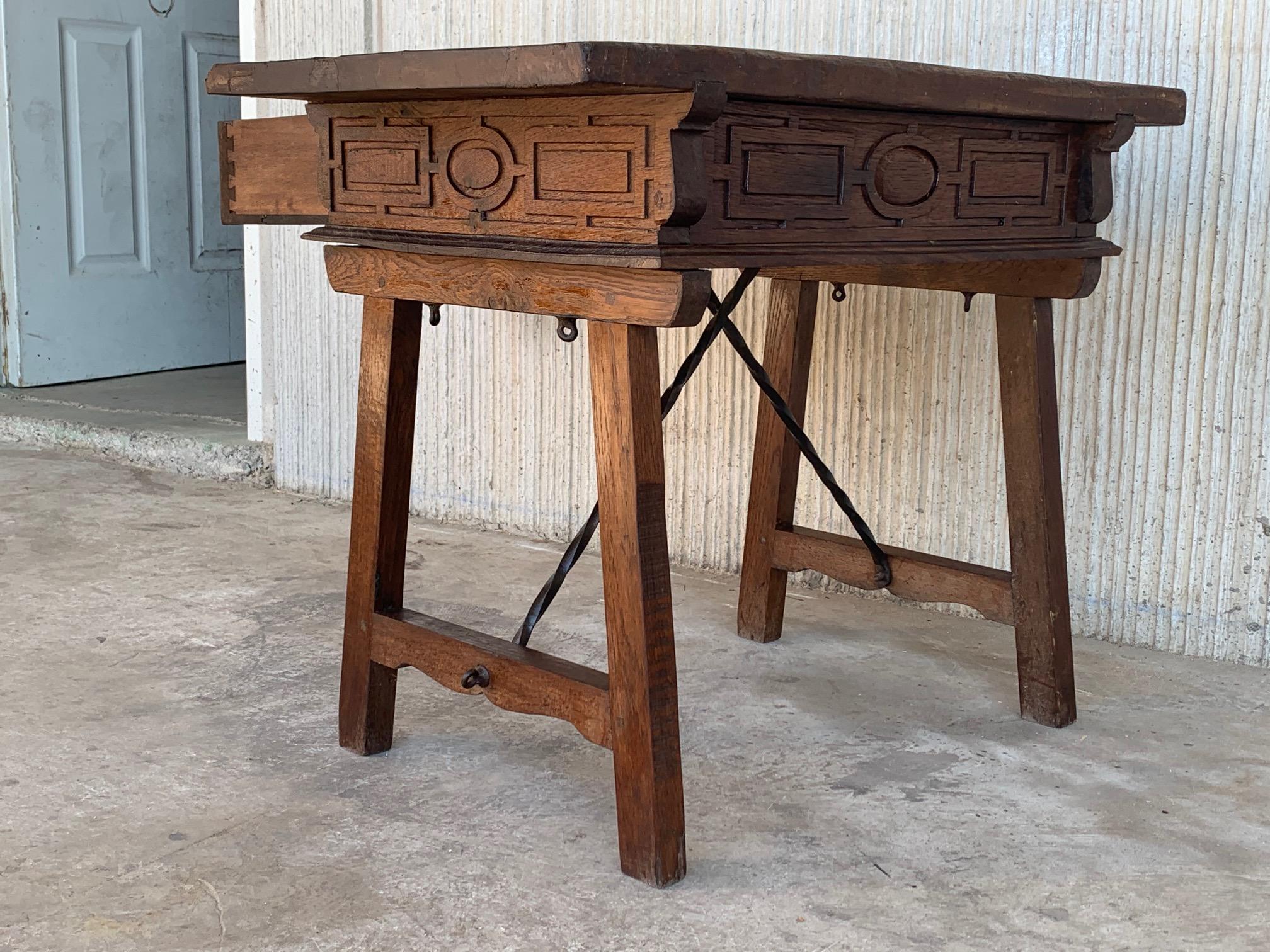 A Spanish walnut side table with single drawer, scalloped apron, carved legs and iron side stretcher from the late 19th century. 
The front it´s the same that the back, you can see in picture 2. 
This elegant Spanish table features a simple,