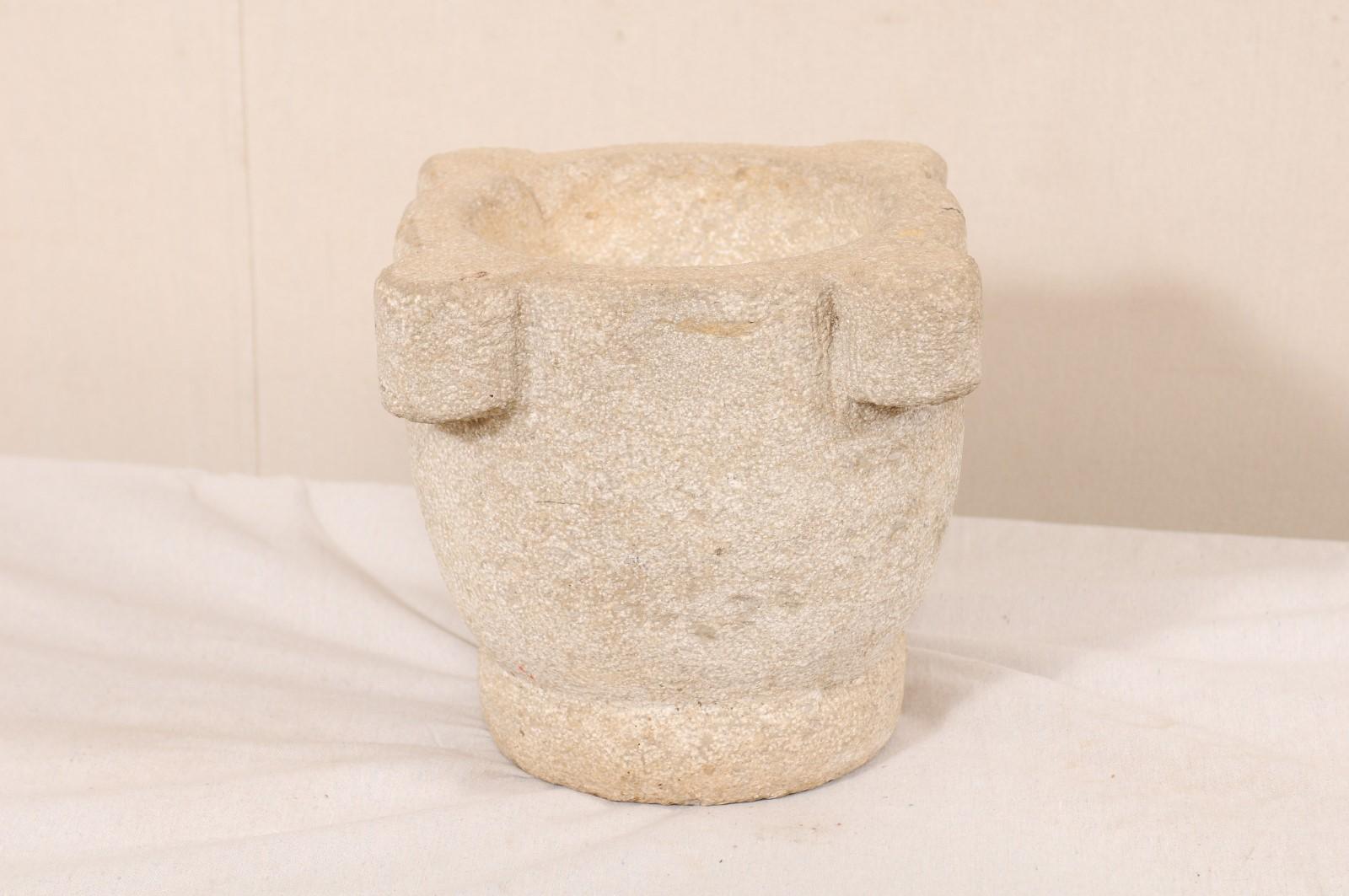 A Spanish 18th century hand carved stone mortar. This antique mortar from Spain, once used to grind various ingredients for cooking or medicinal purposes, is nicely sized standing at 12