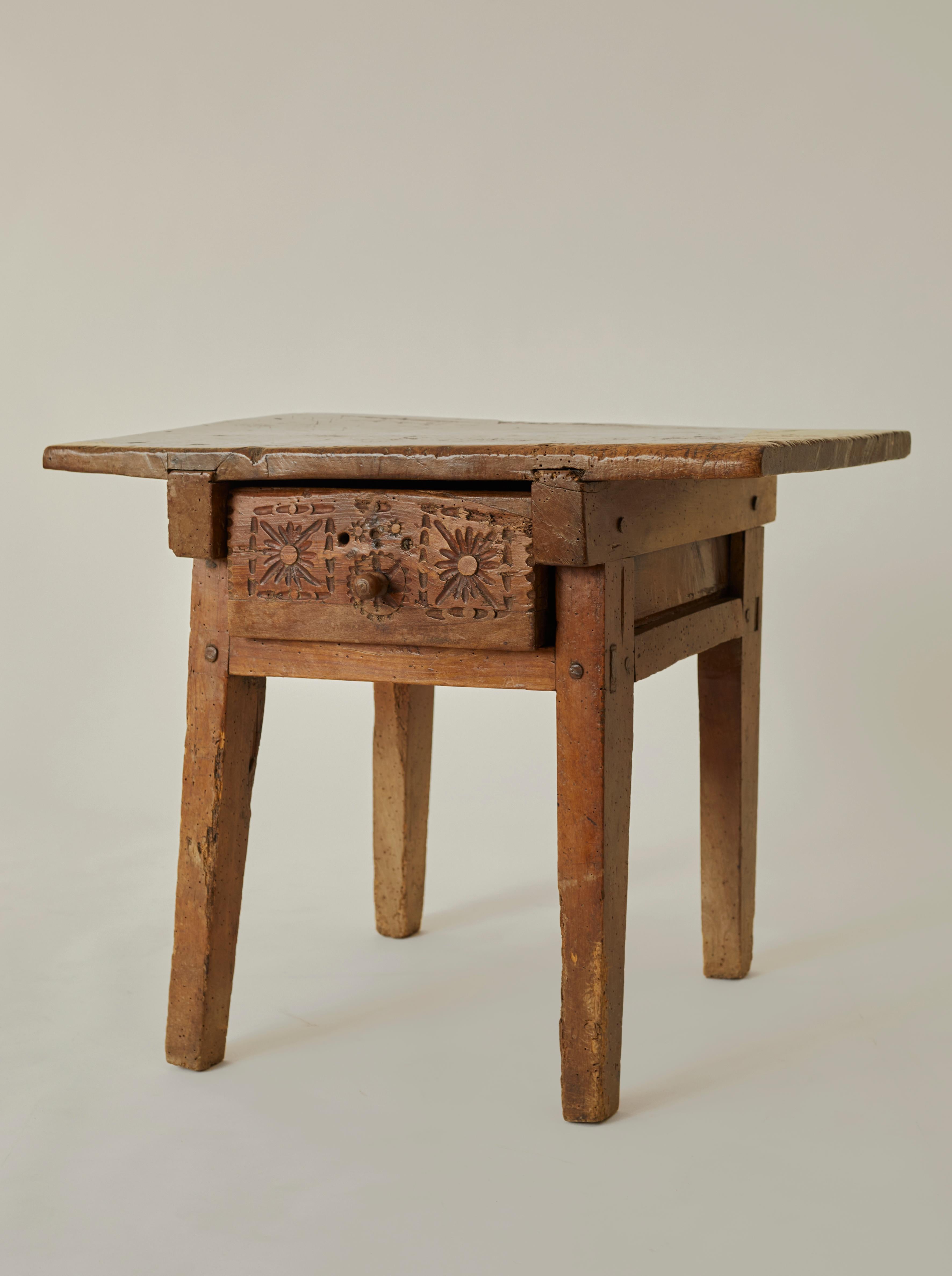 A heavy Spanish 18th century kitchen work table in solid walnut. The table features a beautifully hand-carved drawer and a heavily patinated, buttery-soft top. 

NOTE: The table is wobbly when moved, but otherwise stands steady and can support heavy