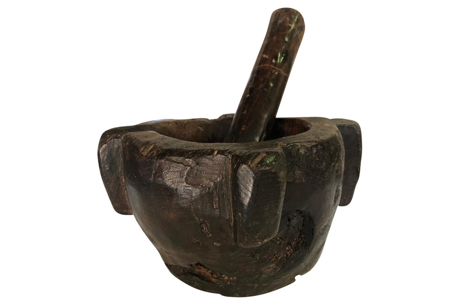 A very handsome 18th century mortar and pestle hand carved from a solid block of wood. Sensational patina. A wonderful object for table top, bookcase or kitchen counter.