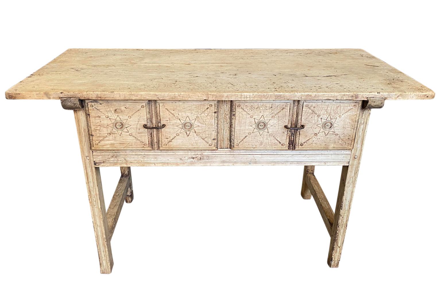 A very striking 18th century primitive Spanish console. Beautifully constructed from naturally washed poplar with two drawers, each with nicely carved facsias and interesting drawer pulls and a solid board top. Wonderful patina.