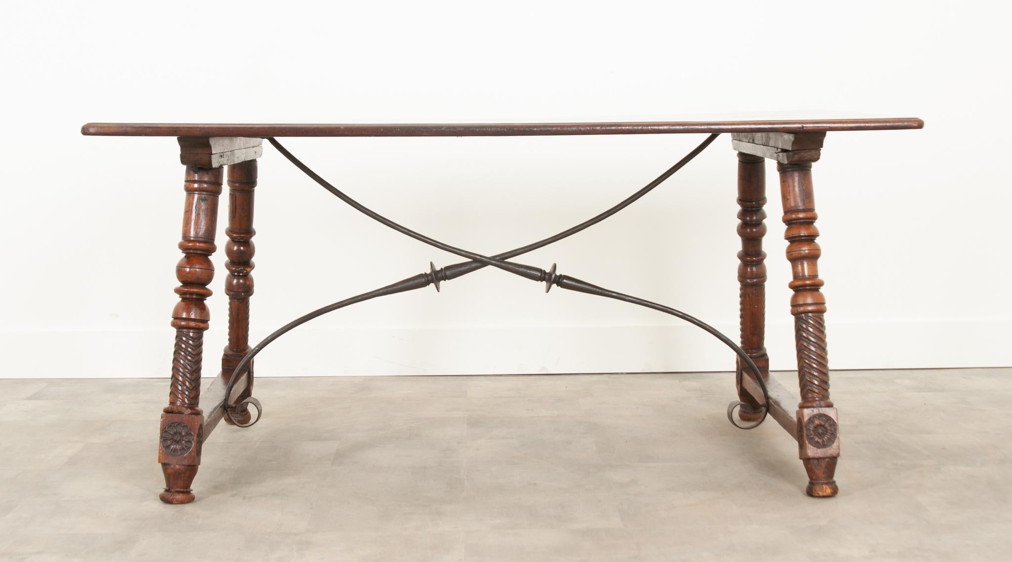 This wonderful Spanish trestle table was handcrafted in the 1700’s and has gained a fantastic patina. The single board, molded edge top is a quality not often found today. Turned legs with amazing carved details support the top and connect with a