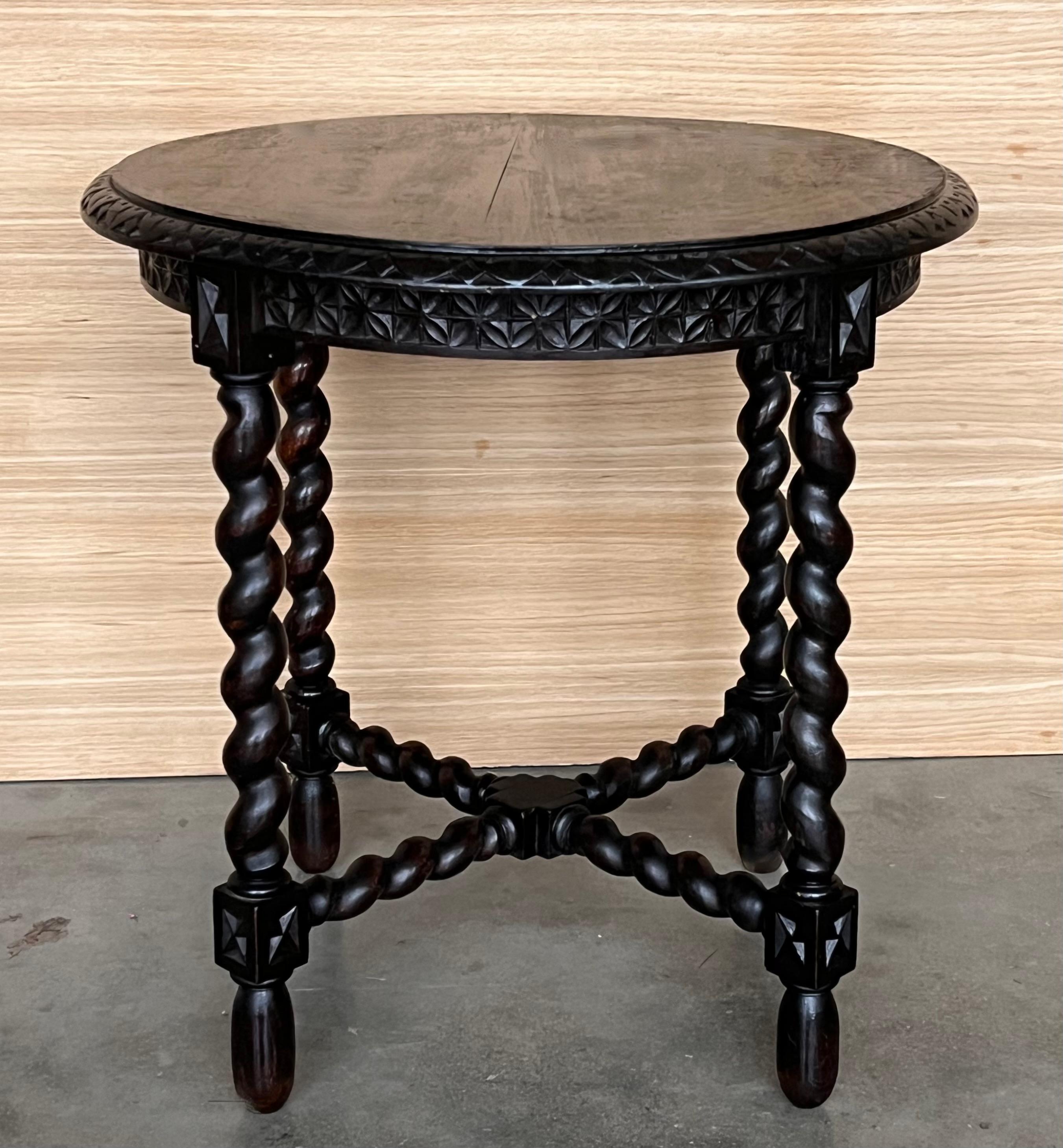 A Spanish walnut side table, scalloped apron and carved legs from the late 19th-early 20th century. This elegant Spanish table features a simple, round top with carved edges. The table is raised on an exquisite base, made of four carved legs, whose