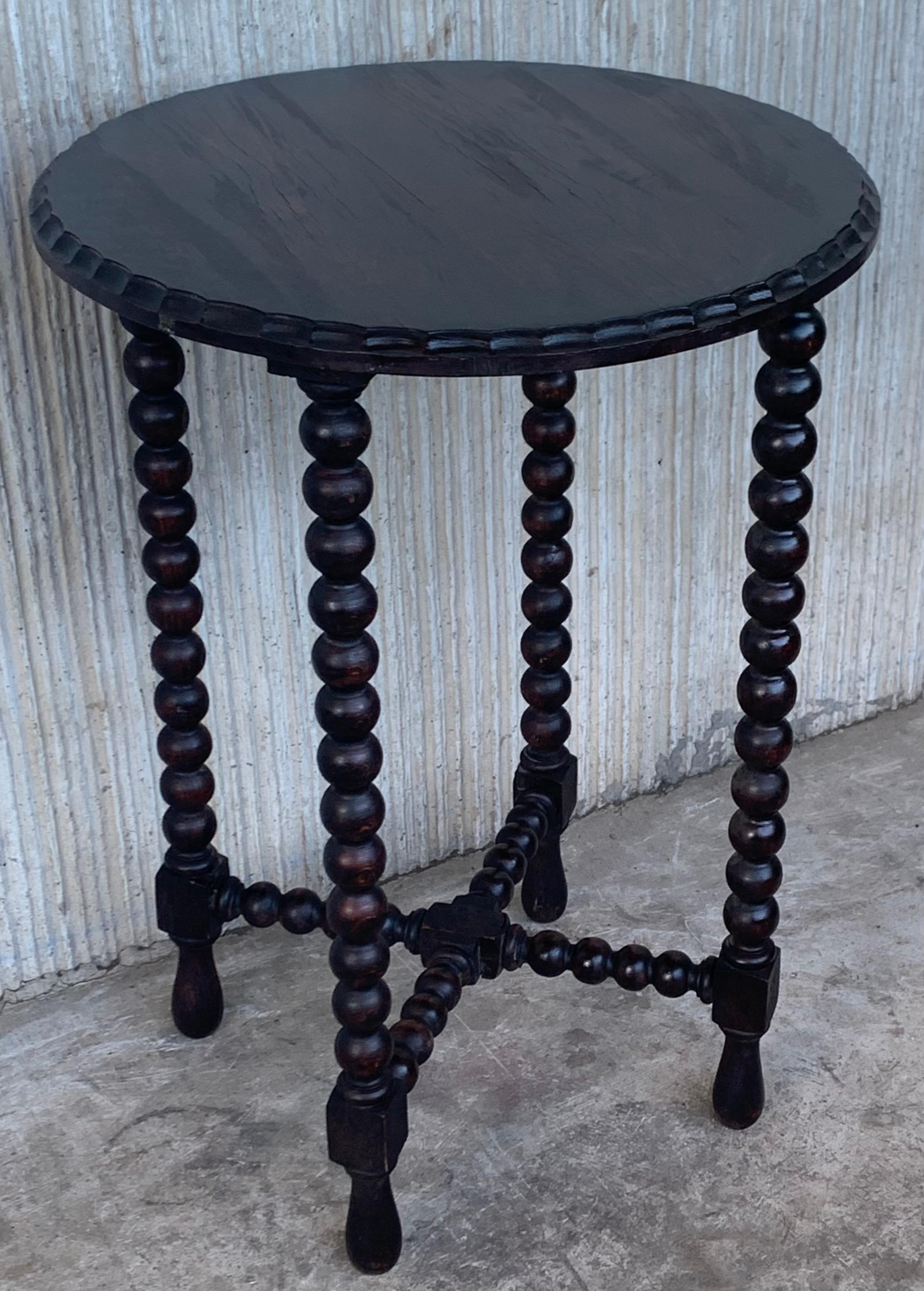 A Spanish walnut side table , scalloped apron and carved legs from the late 19th-early 20th century. This elegant Spanish table features a simple, round top with carved edges . The table is raised on an exquisite base, made of four carved legs,