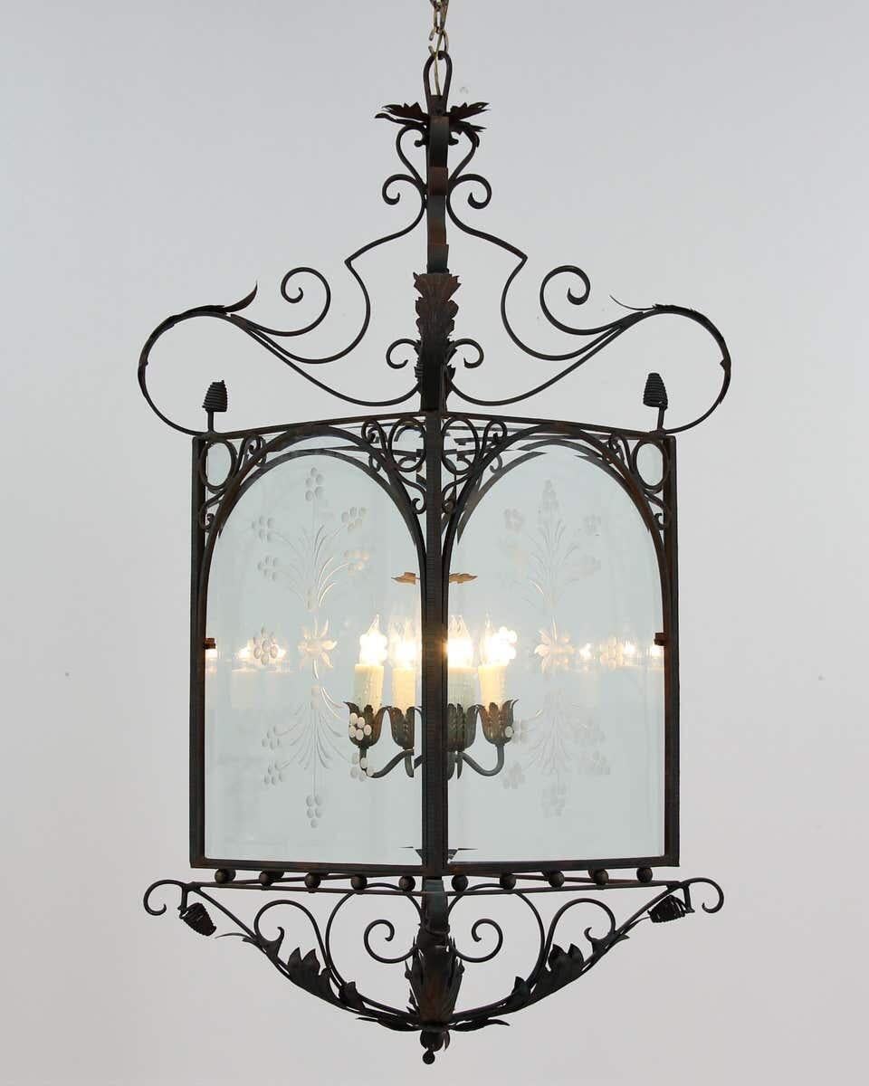 Monumental, 1930s Spanish wrought iron and glass lantern chandelier in the Baroque style. 

This impressive lantern features a painted iron frame with beveled glass panels. The dark green paint on the iron has naturally distressed and shows a