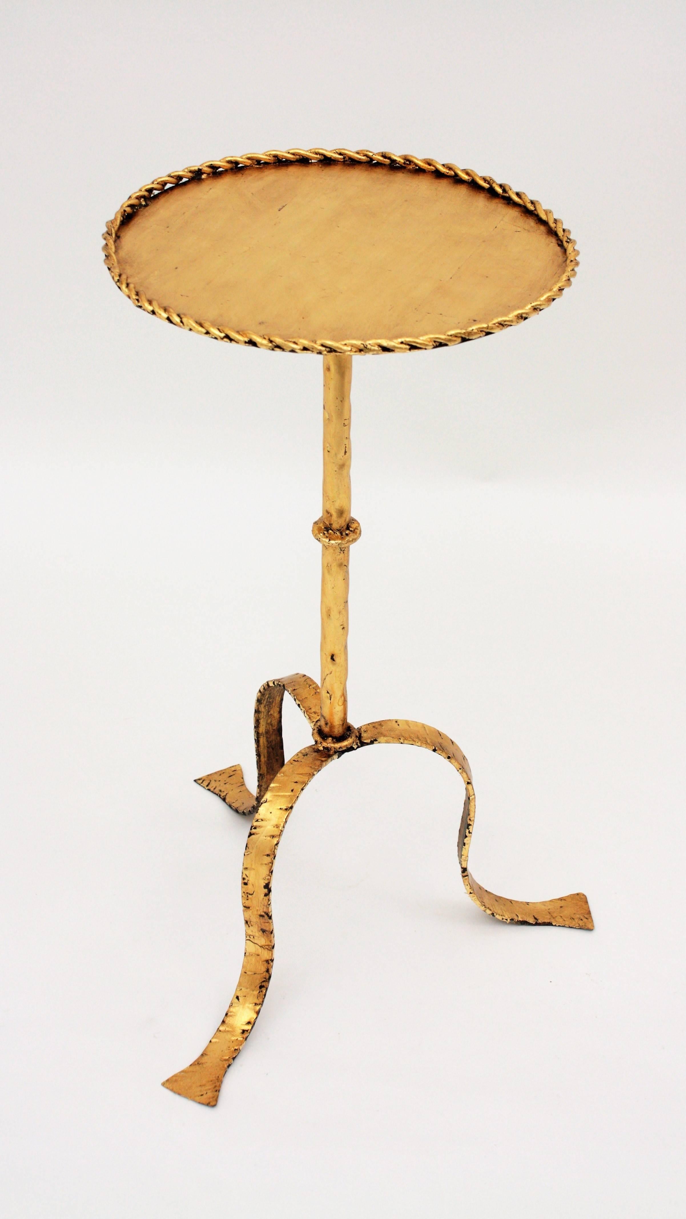 An stylish Gothic style hand-hammered gilt iron gueridon table in gold leaf finish. Useful as side table, smokers table or stand. This piece is in excellent vintage condition. Spain, 1930s-1940s. Diameter of the top: 30cm. 

 
