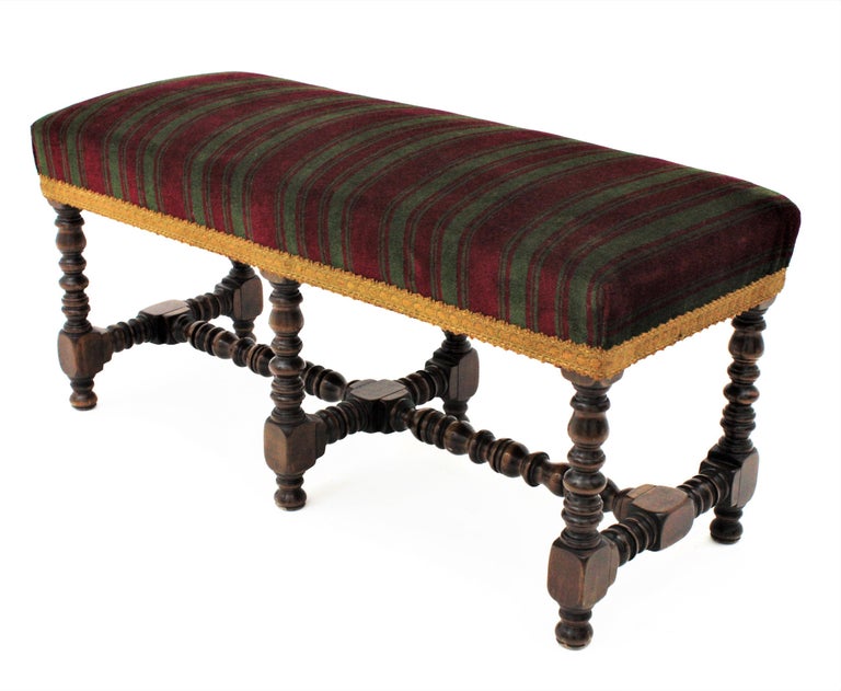 Beautiful mid-20th century Louis XIII style walnut bench or footstool with finely turned legs, stretcher and upholstered seat. Manufactured by Valentí, Spain, 1940s.
This original Valenti low bench or banquette has a turned wood base and an