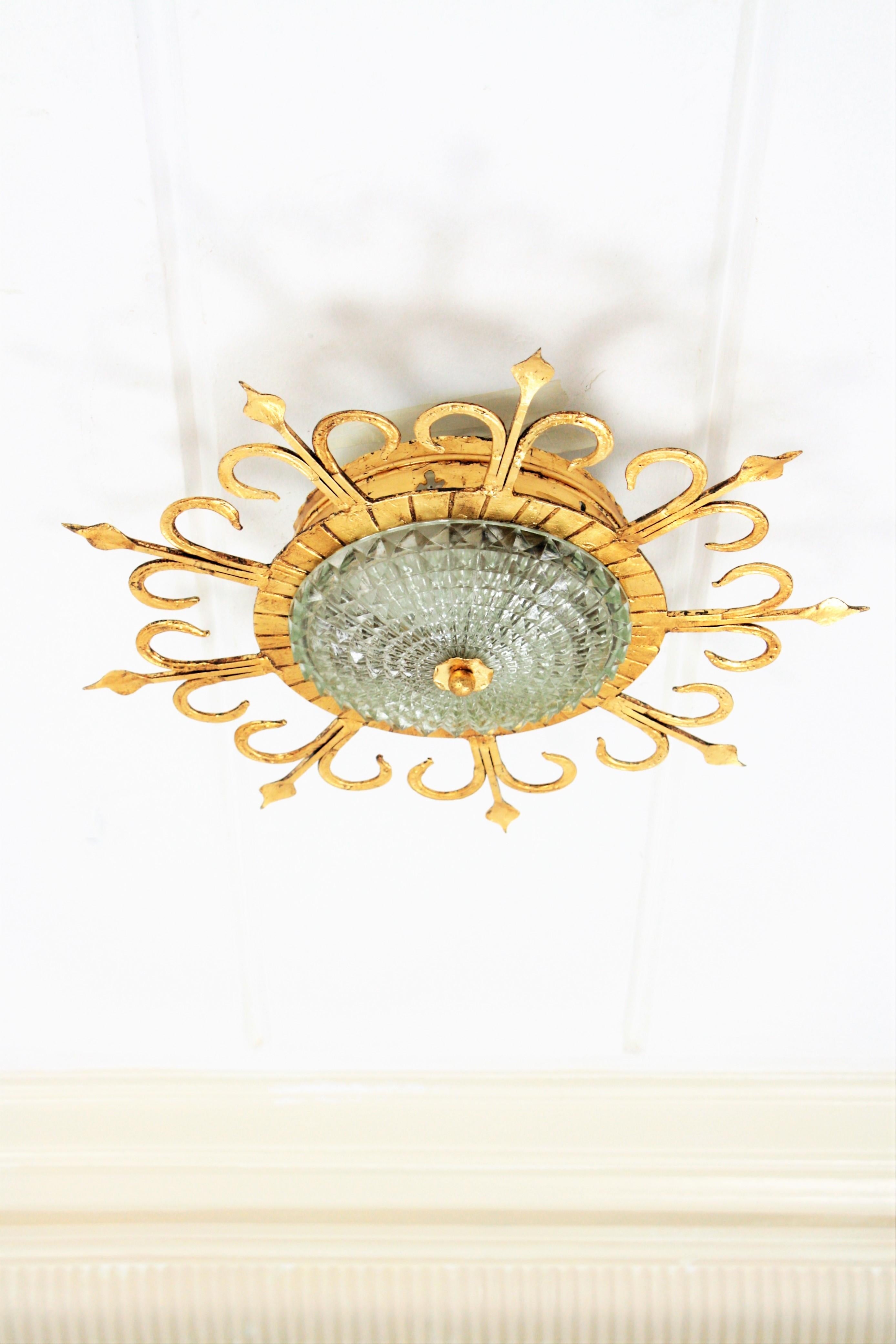 Beautiful hand-hammered iron and glass ceiling light fixture with neoclassical and Gothic Revival accents. A forged iron with gold leaf finish fixture, a pressed frosted glass shade with a gilt iron ball finial. This lamp has an highly decorative