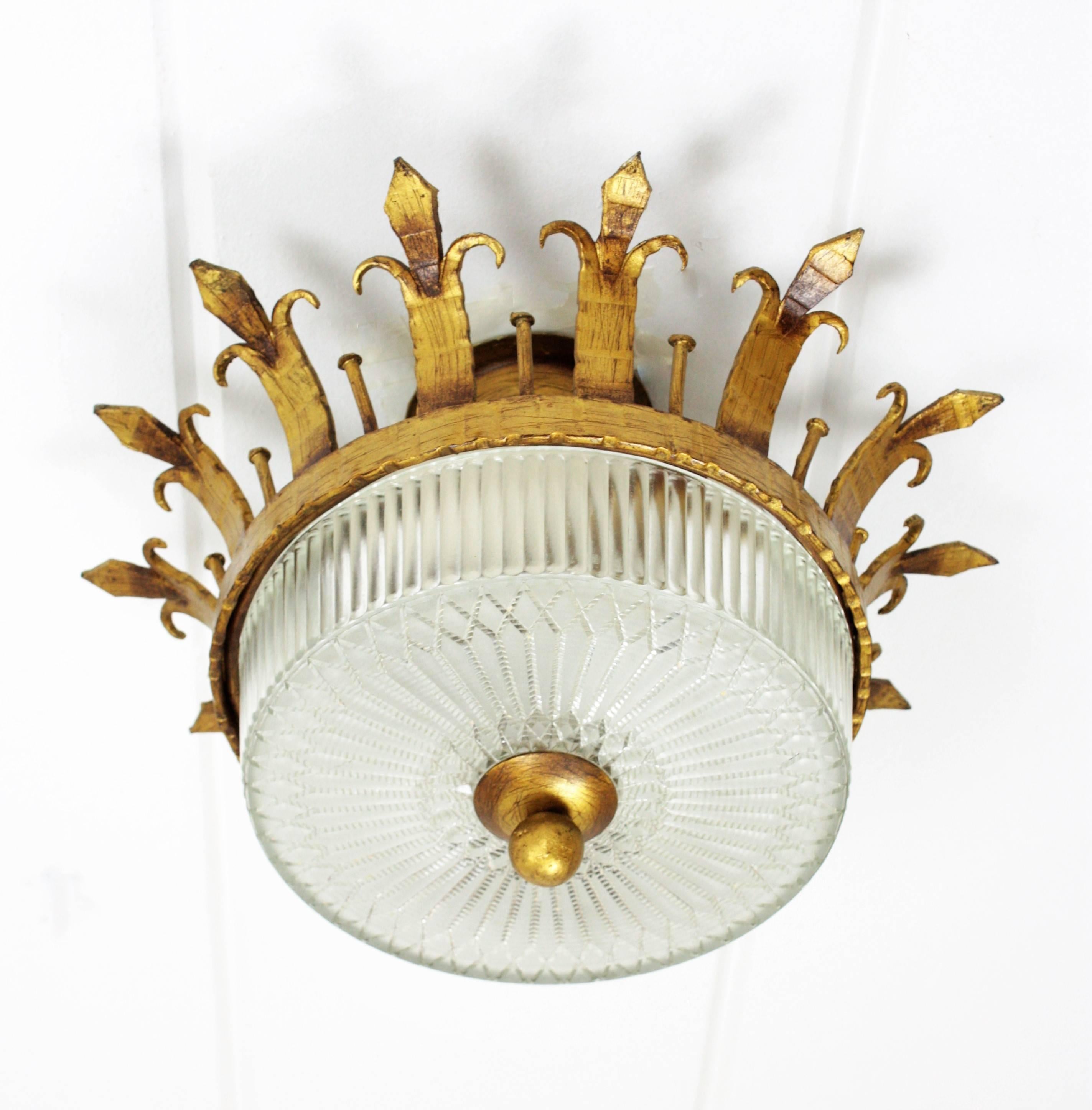 An sculptural hand hammered iron and glass ceiling light fixture with neoclassical and gothic revival accents. A forged and gilded iron fixture with canopy and a fluted frosted glass shade with a gilt iron ball finial. This lamp has an highly