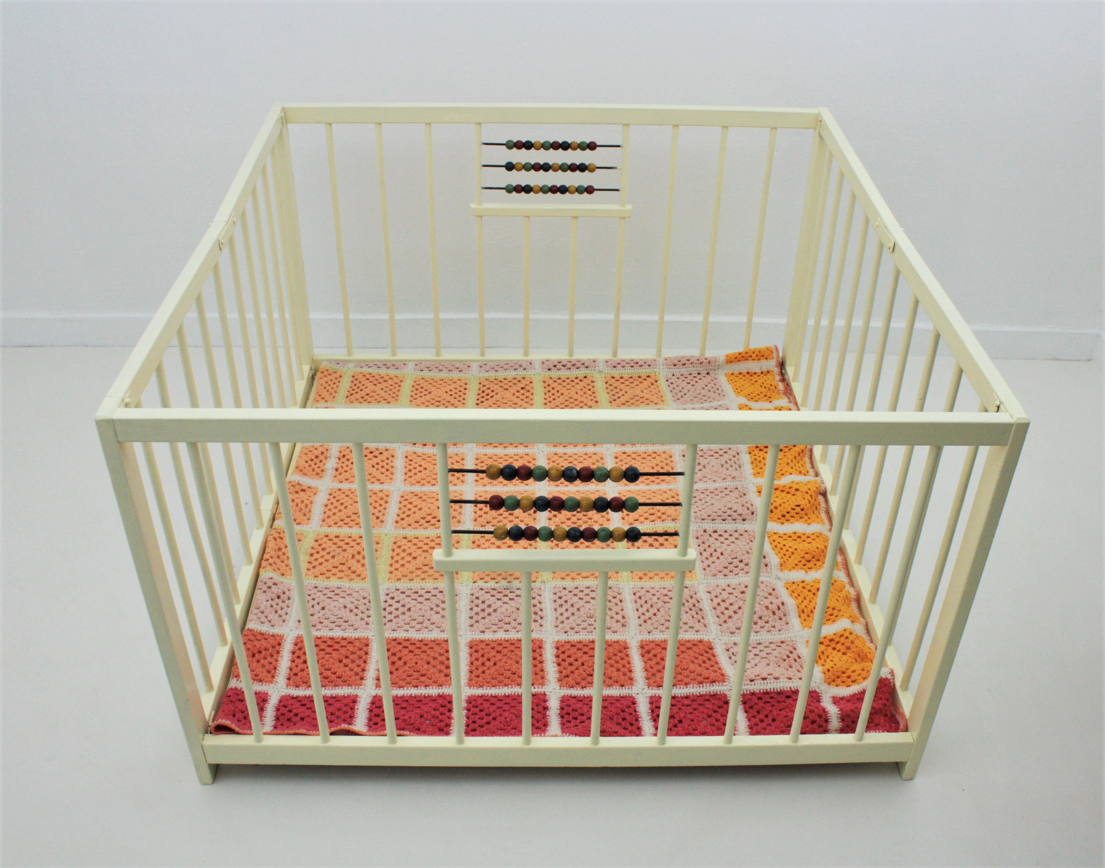 A lovely wood painted folding kids crib playpen with abacus toys at both sides. Spain, 1940s-1950s
Easy to fold to store it.
It is useful as portable crib or playpen.
The crochet blanket is included
Measures:
Open 106 cm W x 106 cm D x 66 cm