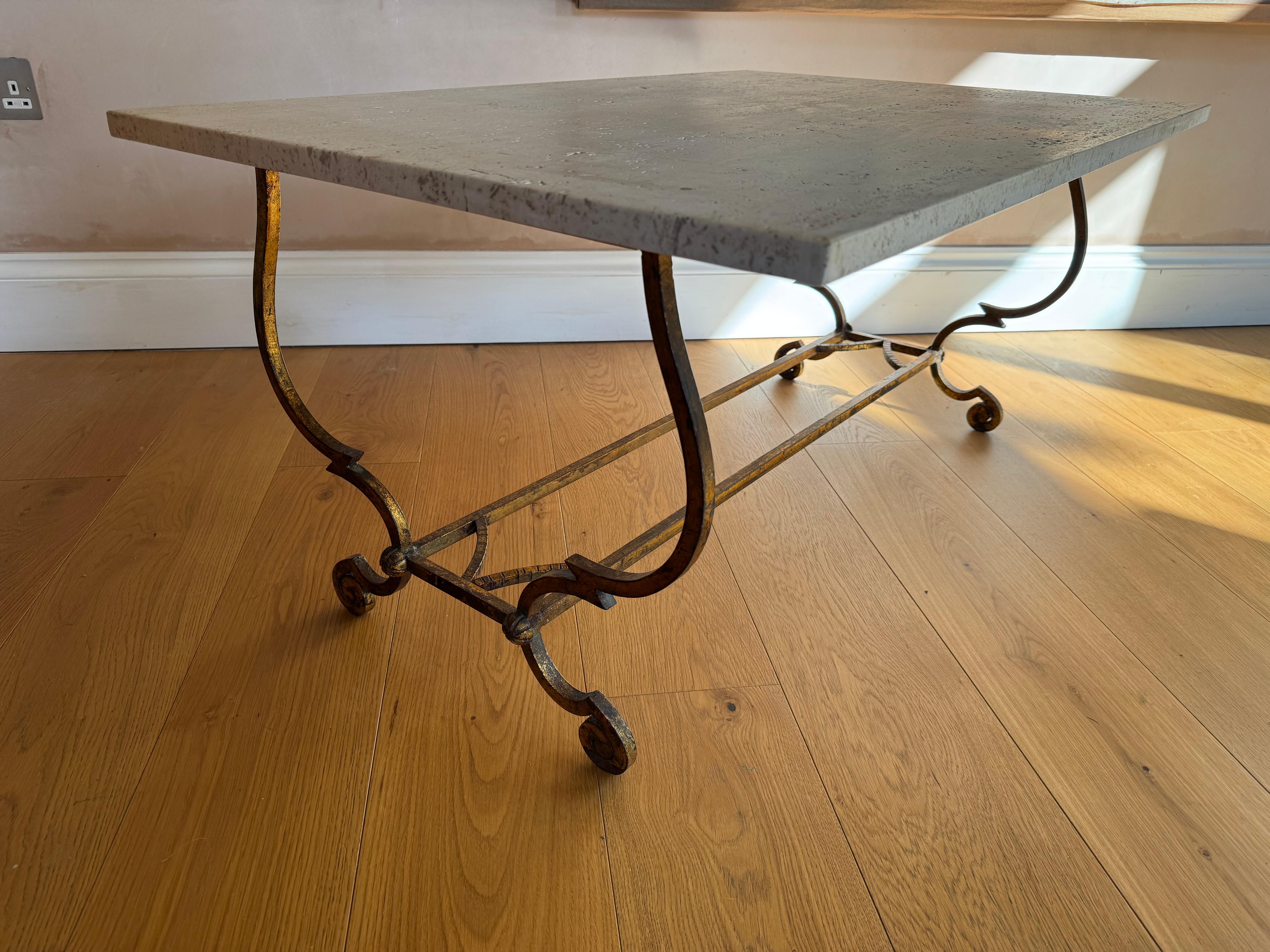 Une élégante table basse en fer doré et pierre de travertin. 