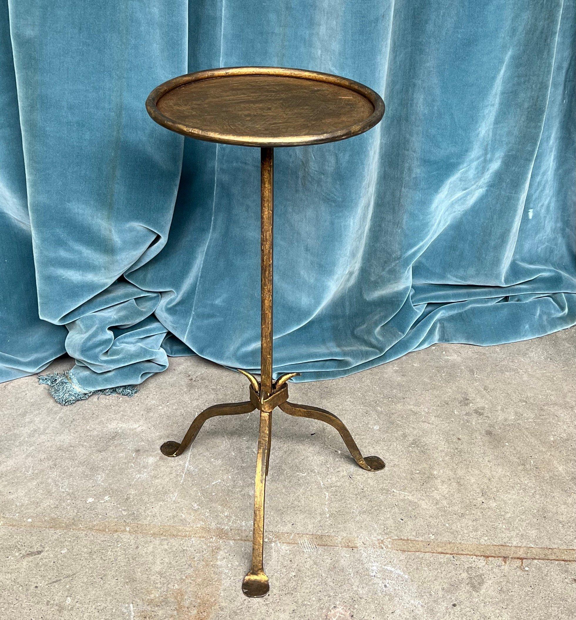 This captivating iron drinks table hails from Spain and dates back to the 1950s. Its design boasts a central stem that narrows gracefully towards an elegant point, seamlessly merging with a tripod base made up of three delicately curved legs. The