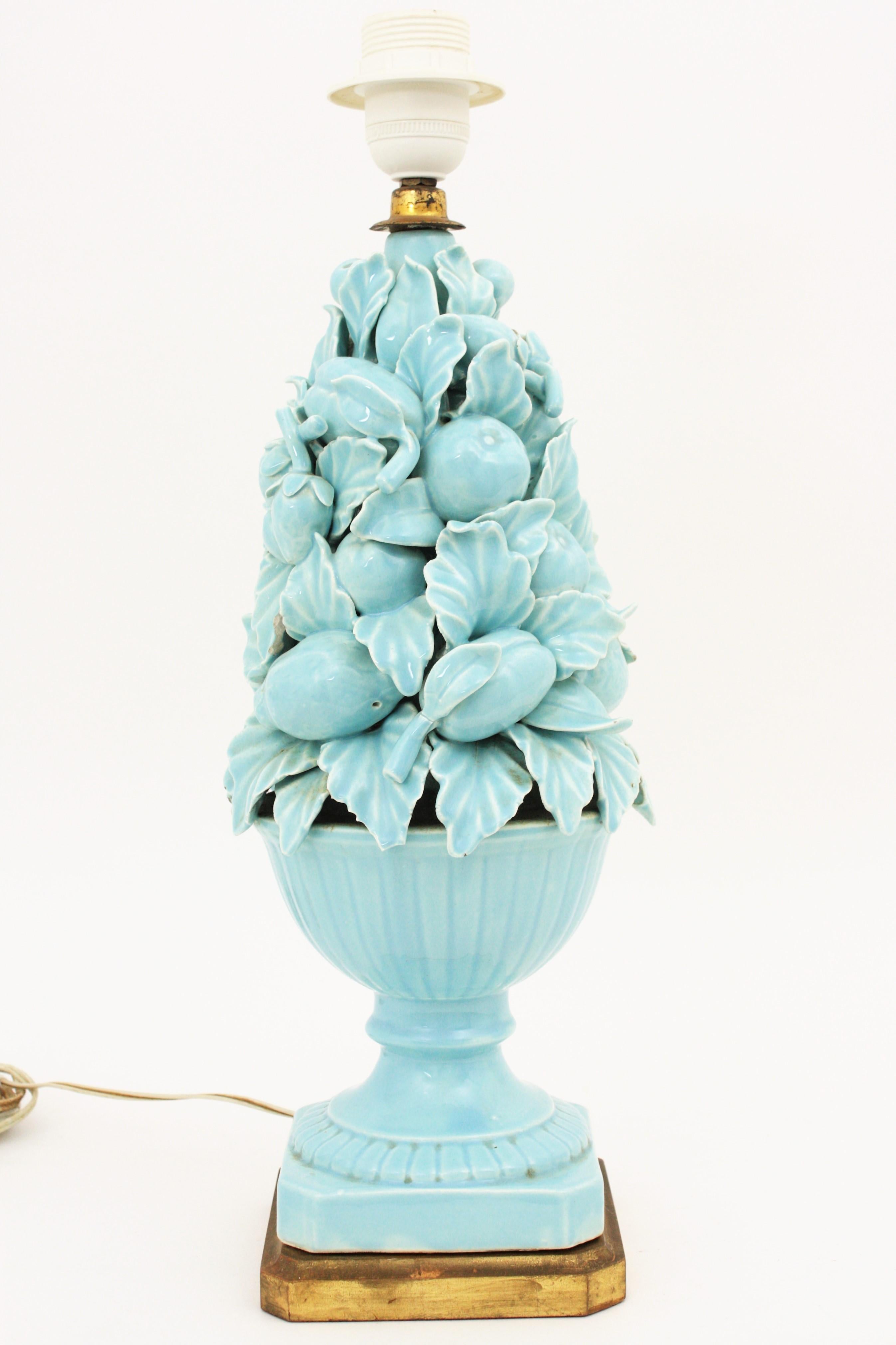 Beautiful blue glazed Manises ceramic lamp with fruity motifs and leaves and a giltwood pedestal. Manises, ( Spain) had a long tradition tradition producing ceramics, majolica, terracotta and porcelain pieces. 
Excellent condition. 
 