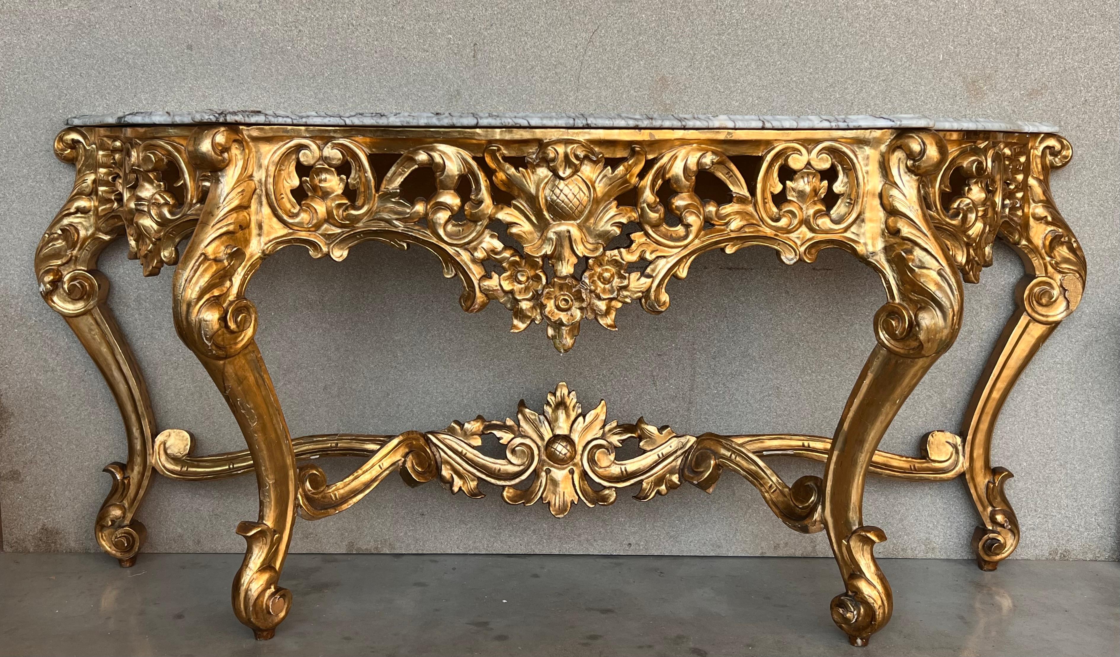 A magnificent and large scale Spanish 20th century Baroque style, ormolu and white marble freestanding console. The most impressive console is raised by elegant scrolled acanthus leaf feet below the powerful scrolled legs with richly carved flowers