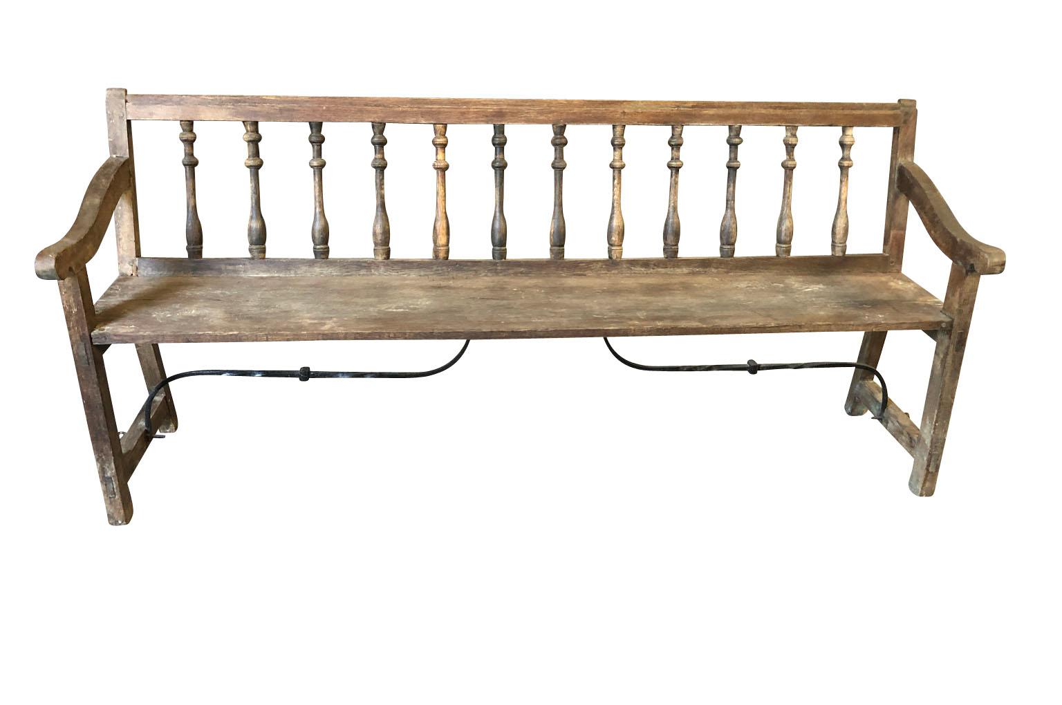 A very charming mid-19th century bench from the Catalan region of Spain. Soundly constructed from beautiful naturally washed chestnut and hand forged iron stretchers. Perfect for any casual interior of porch. Measures: Seat height 19 3/8