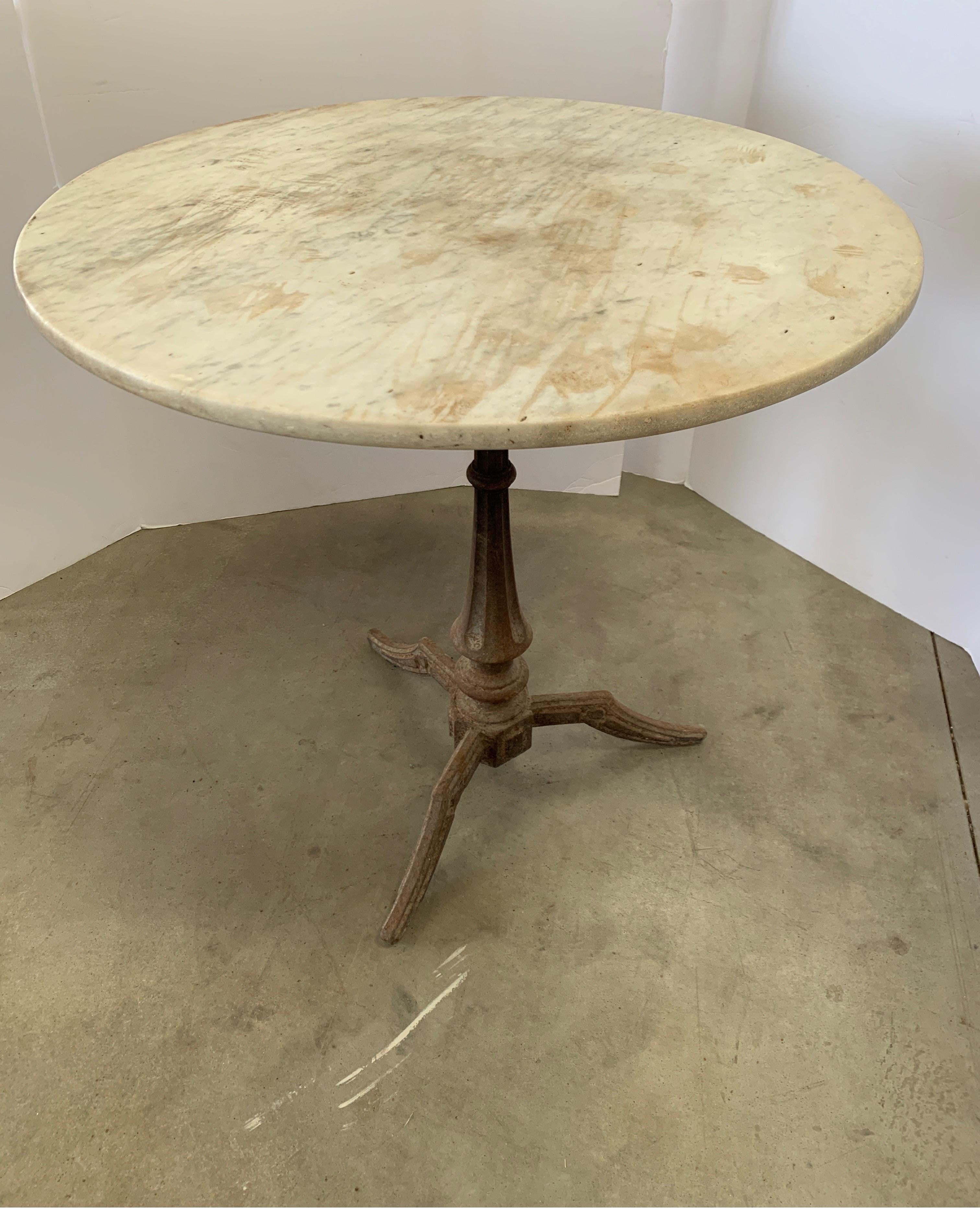 This is a great antique bistro table with iron base and it’s original top. It has had lots of use, therefore you can see it in the stains and wear on the marble. It creates wonderful character with loads of past conversation.
