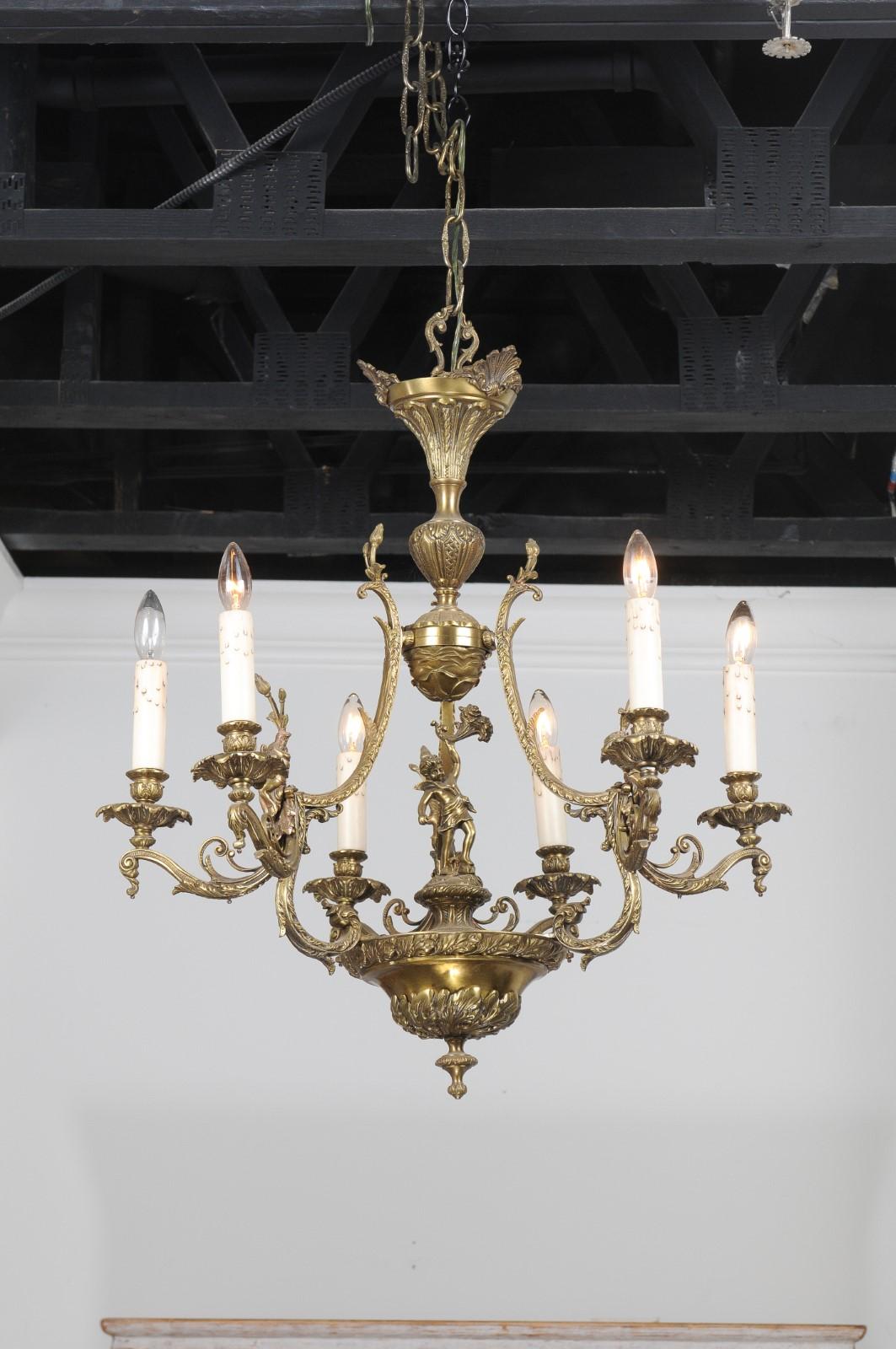 A Spanish bronze six-light chandelier from the 19th century with cherubs, floral and foliage motifs. Our eyes are immediately drawn to this bronze chandelier created in Spain during the 19th century. A delicate foliage decor adorns the structure and