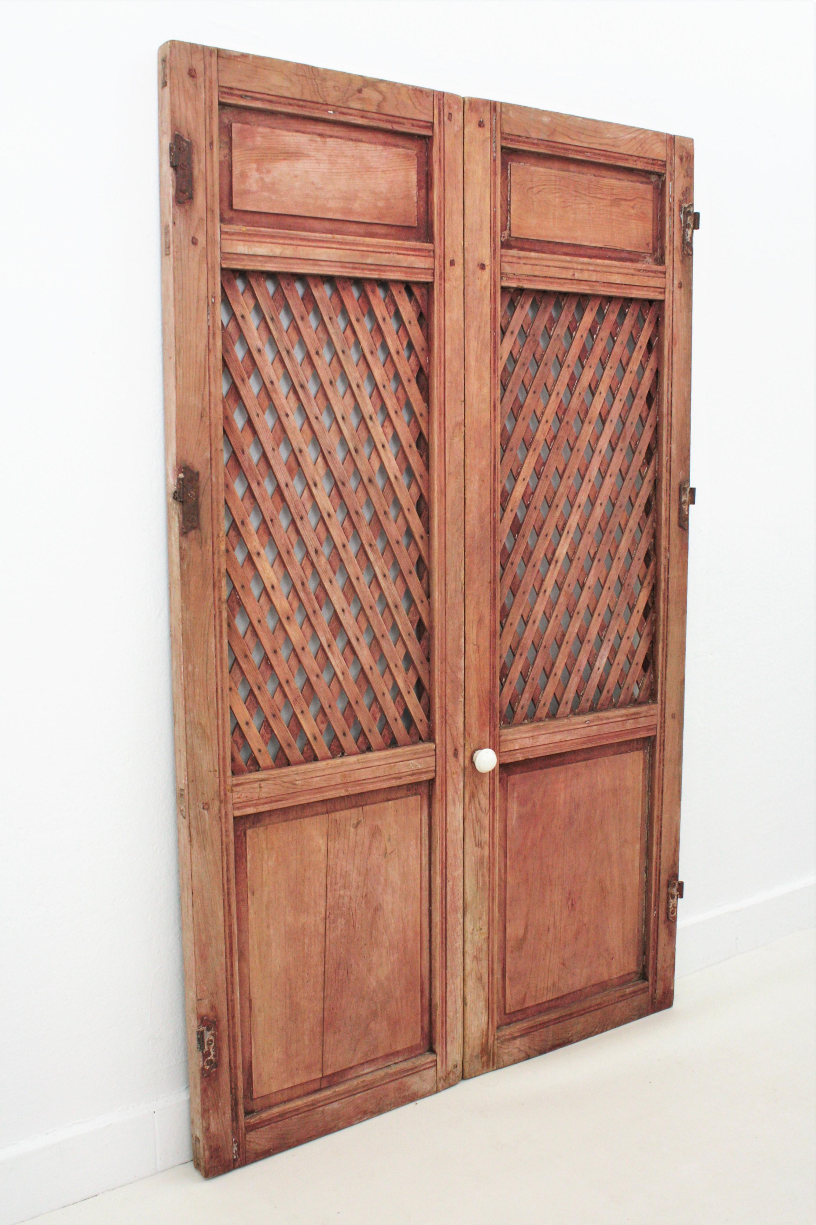 Antique Spanish 19th century cupboard rustic doors with lattice and carved panels, early 19th century.
These antique doors come from a cottage house in Galicia at the North coast of Spain. They were part of an antique lattice food