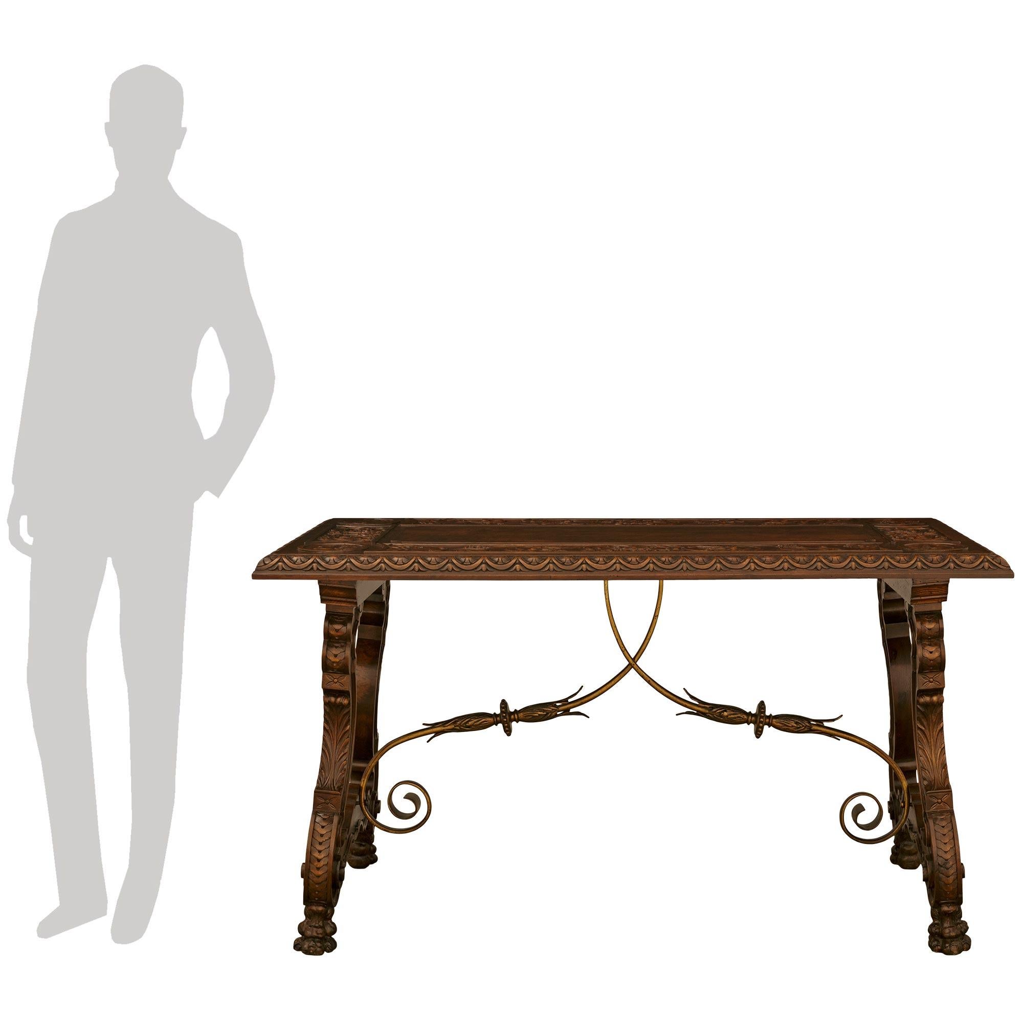 Magnifique table à tréteaux en noyer et laiton de style Renaissance espagnole du XIXe siècle, aux détails complexes. Cette table exceptionnellement décorative est surélevée par quatre beaux pieds pattes richement sculptés sous les impressionnants