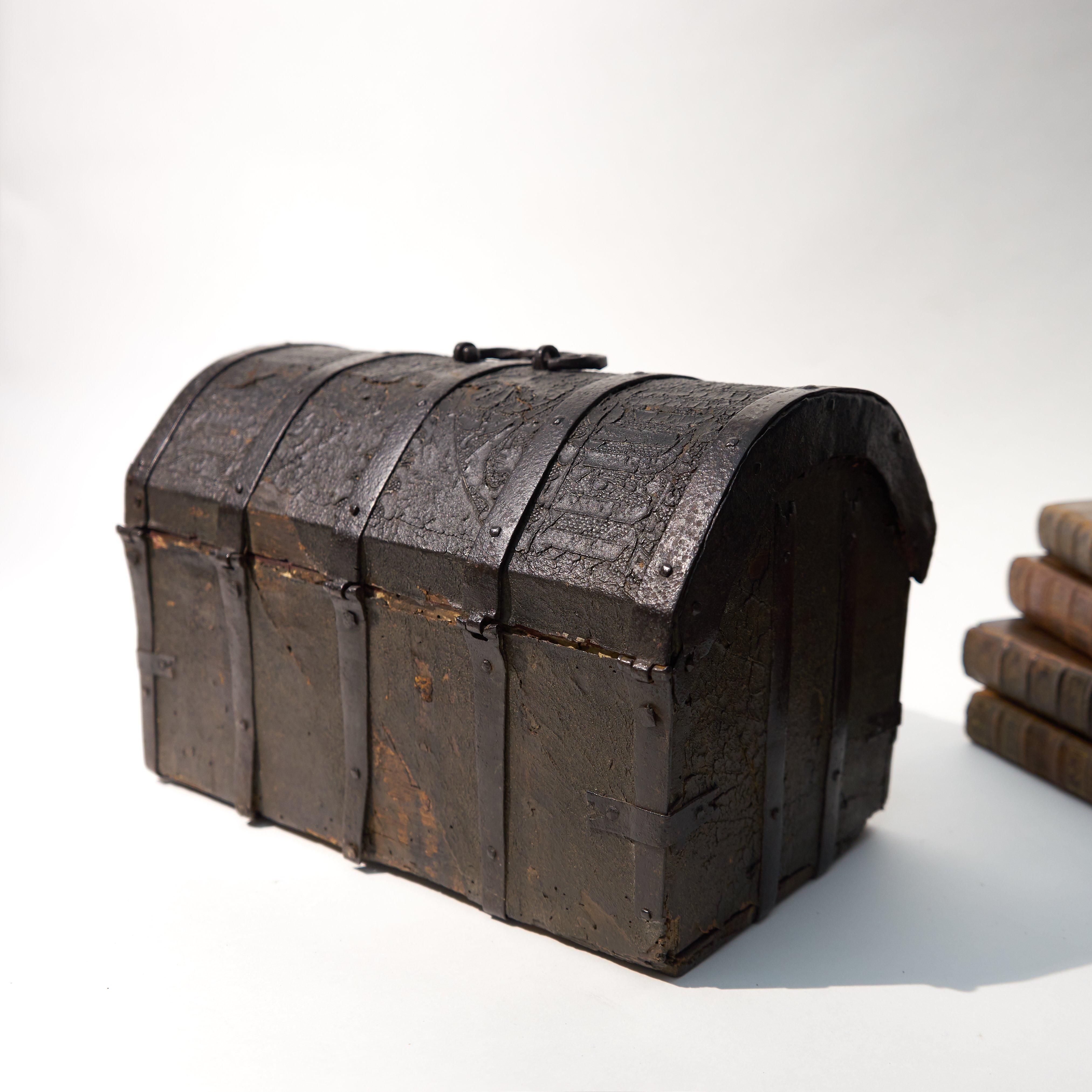 The box is an iron-mounted Cuir Bouilli casket.
Coffrets or small boxes, made from wood and covered with leather were often used to store
documents or other desk objects. It is decorated with floral patterns and includes three
inscriptions in