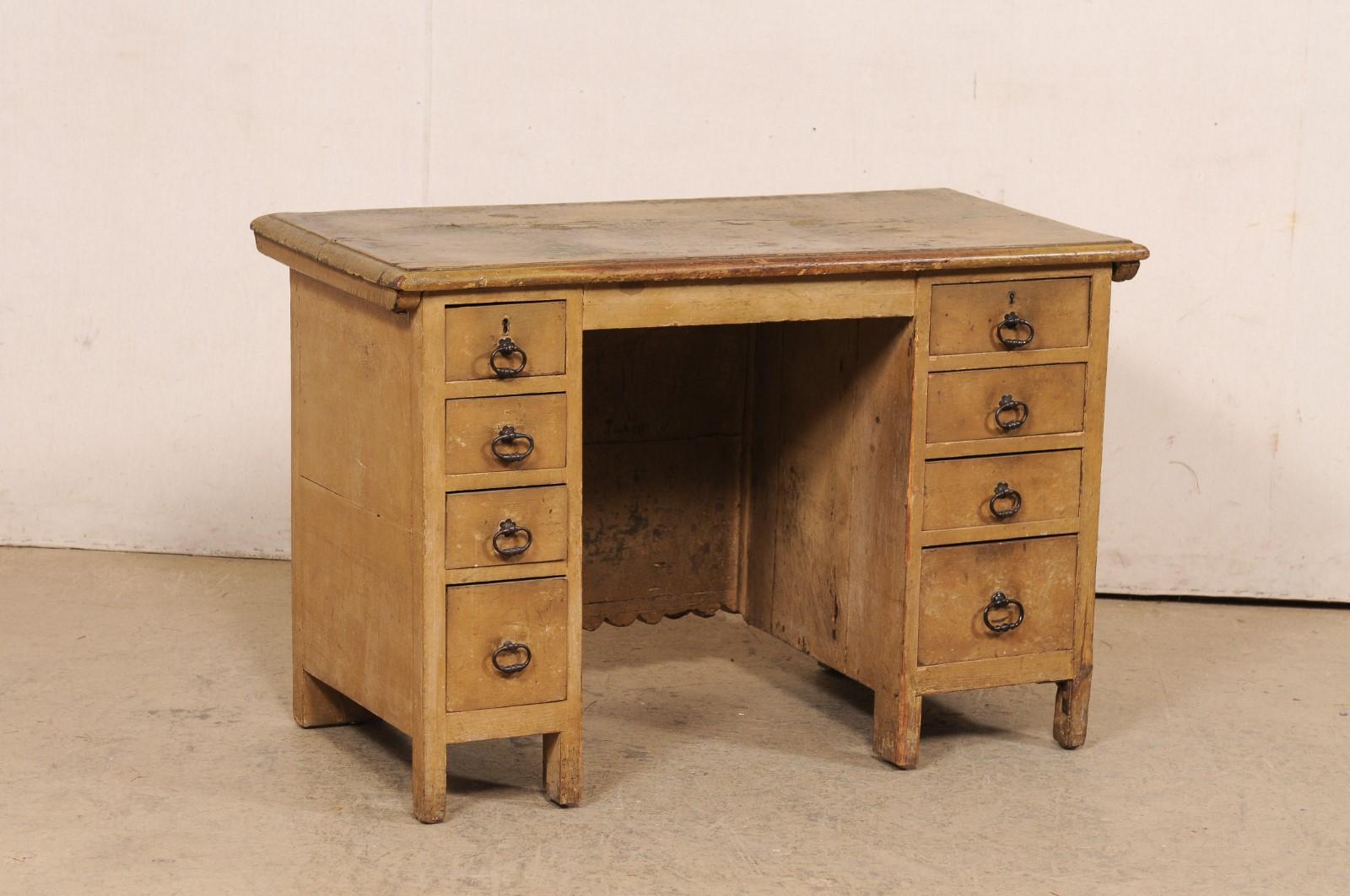 A Spanish smaller-sized wood desk, with a trunk-like appearance from front, from the early 20th century. This antique desk from Spain features a nicely carved front side, filled with square and circular medallions framing flower heads set into a
