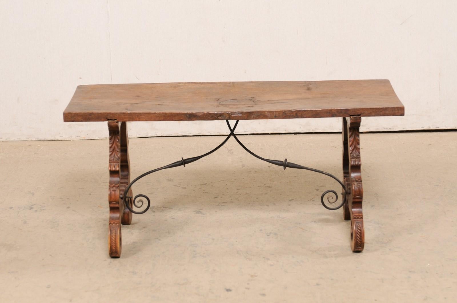 20ième siècle Table basse espagnole ancienne en bois avec pieds en forme de lyre sculptés et jolis brancards en fer en vente