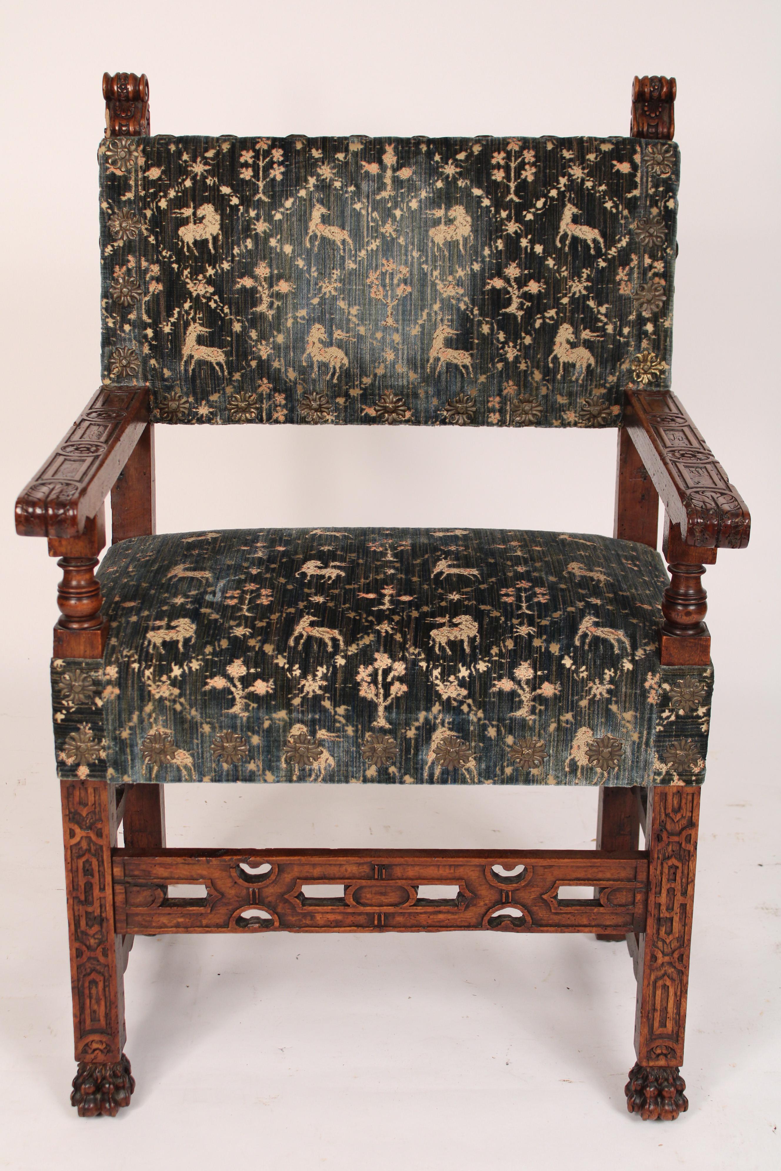 Antique Spanish carved walnut armchair with old cut velvet fabric, 19th century. Nicely carved chair frame, old walnut has excellent patina, old worm holes, interesting cut velvet fabric with animals and brass nail heads. Peg construction.