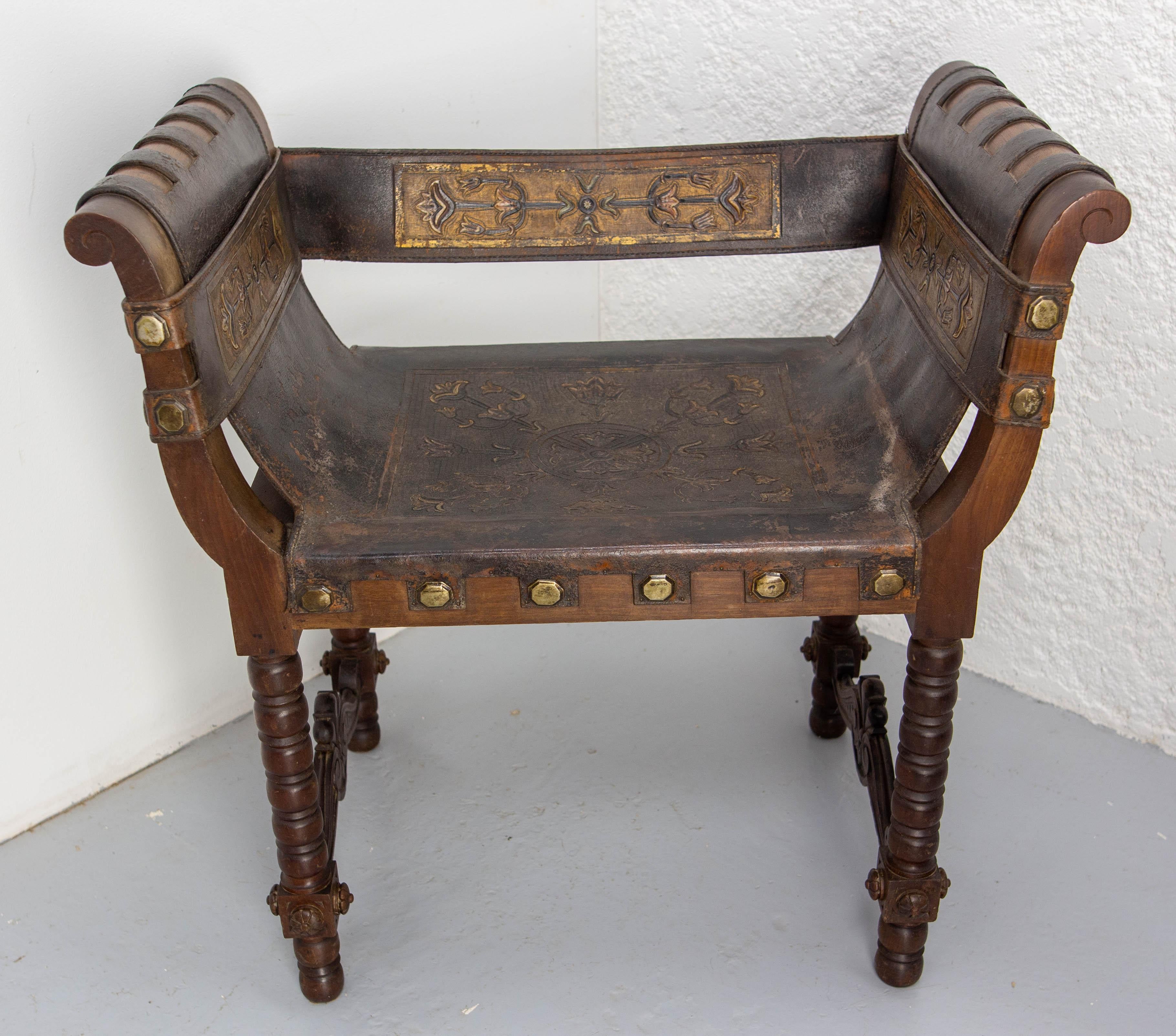 Spanish seat, in the curule styla, made circa 1880 
The cordovan leather used for the seat is held in place by studs. Strips of embossed leather are used for the backrest and armrest decoration. At the rear, the backrest has been reinforced with a