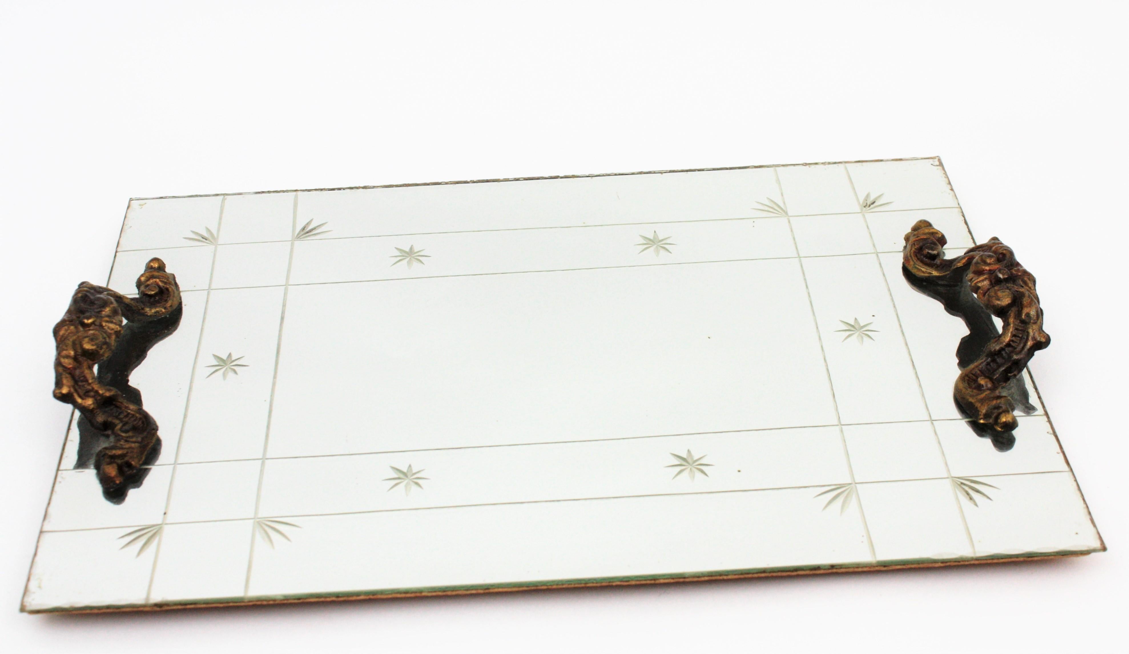 Art Deco mirror serving tray or vanity tray with engraved motifs and bronze handles. Spain 1920s
The tras a mirror surface with stars, leaves and stripes engraved details, naturalistic motifs decorating the handles and it shows a beautiful antique