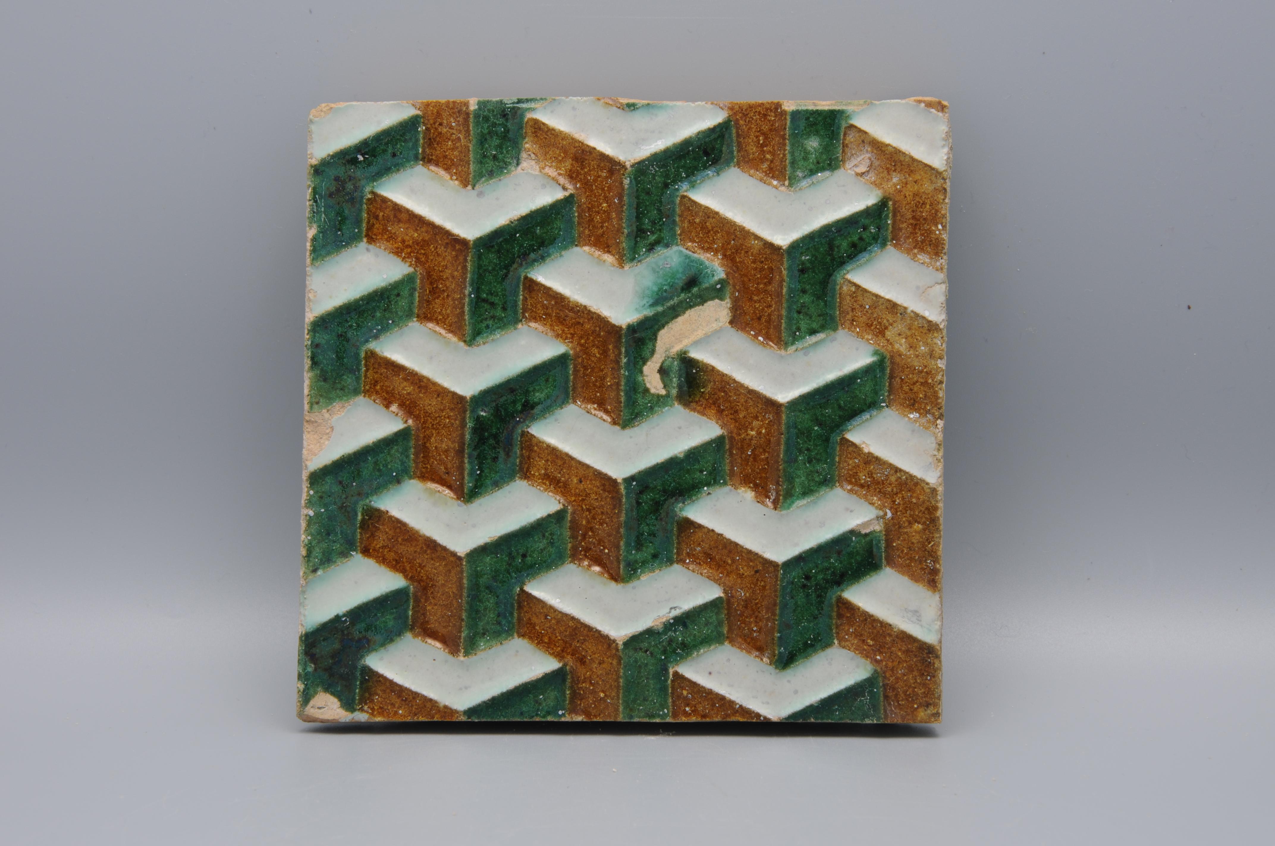 Carreau Arista y Cuenca de la première heure, probablement fabriqué à Séville. Carreau azulejo décoré dans le style renaissance nasride de motifs géométriques. Les mêmes carreaux se trouvent dans le monastère de Cartuja à Séville. 
Probablement