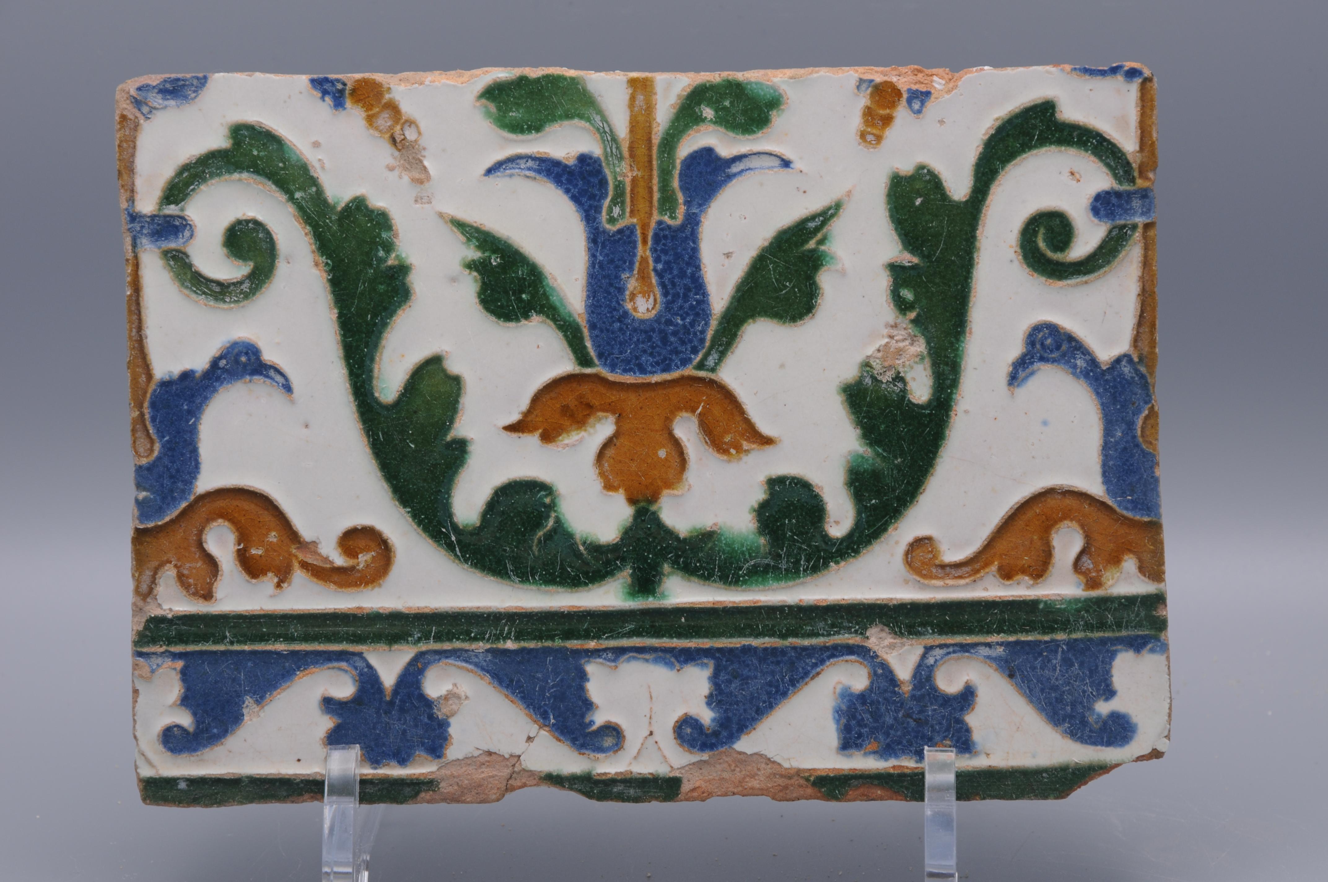 Frammento di piastrella Arista y cuenca realizzata a Toledo. La piastrella decorata in stile rinascimentale con fiori stilizzati è stata probabilmente realizzata tra il 1550 e il 1575. 


 Perdite e usura. 