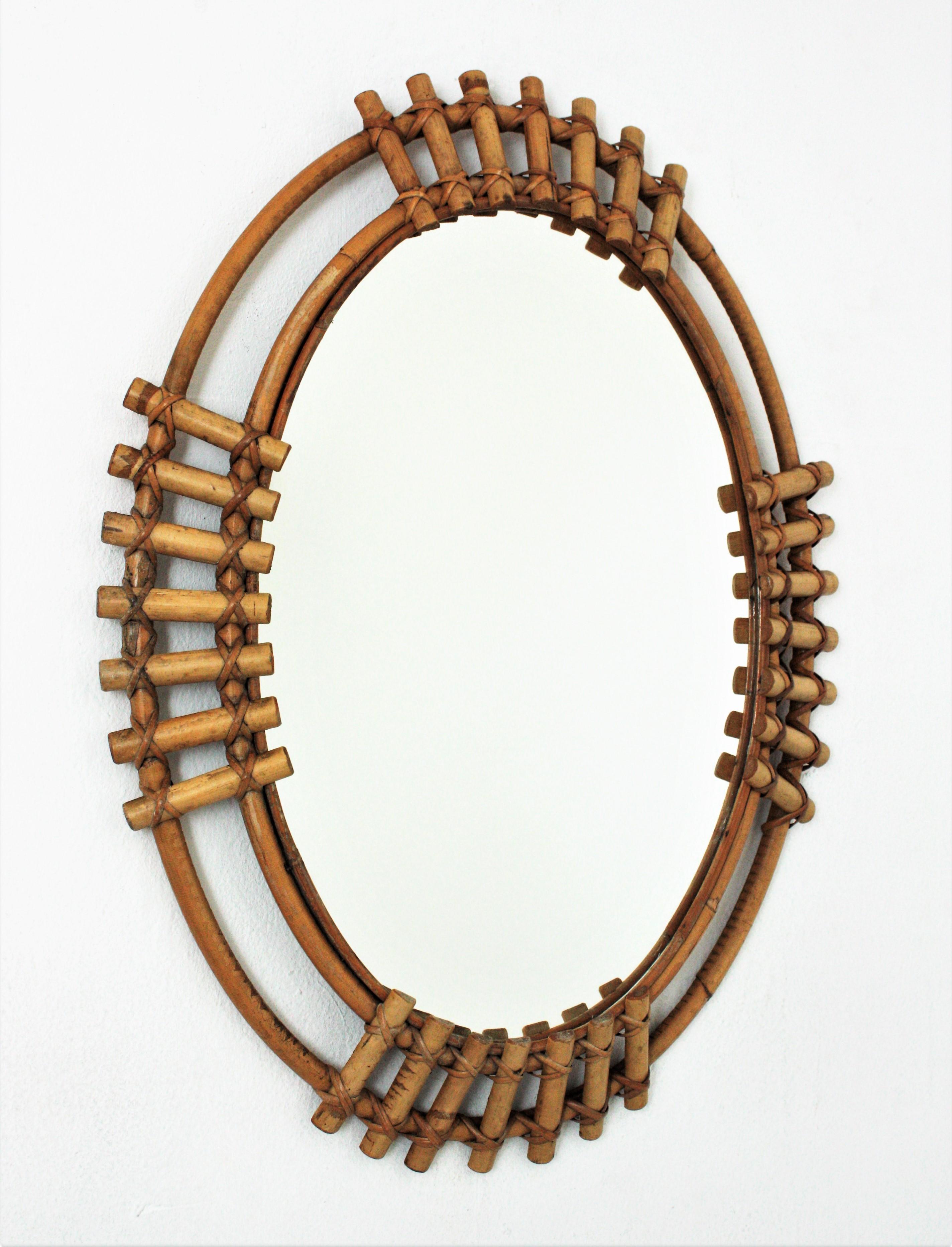 Eye-catching Mid-Century Modern bamboo oval sunburst mirror, Spain, 1960s.
This wall mirror features a bamboo double frame with split bamboo canes in sunburst disposition.
The large mirror surface allows to use it in a bathroom, dressing room or