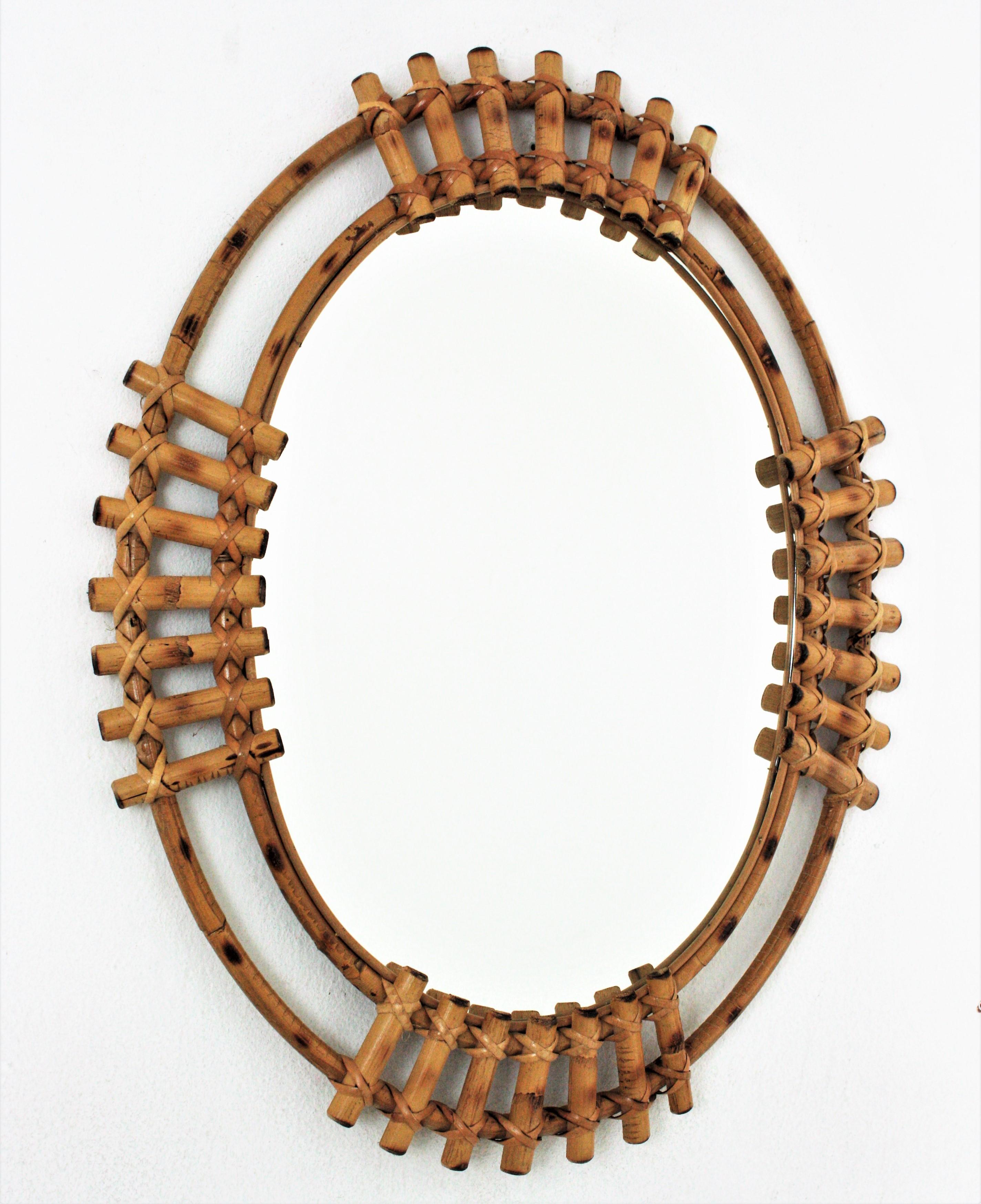 Eye-catching Mid-Century Modern bamboo large oval sunburst mirror, Spain, 1960s.
This wall mirror features a bamboo double frame with split bamboo canes in sunburst disposition.
The large mirror surface allows to use it in a bathroom, dressing