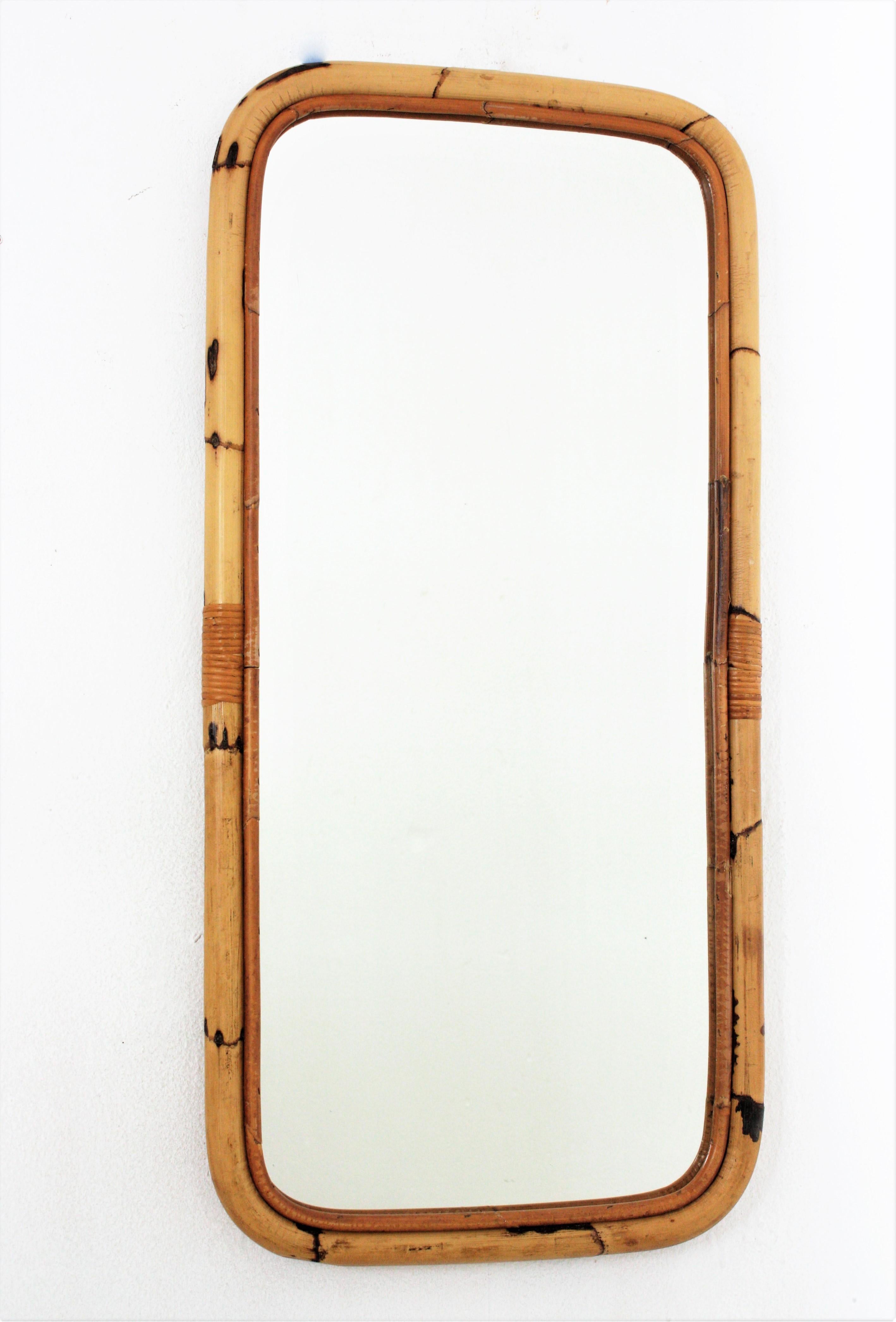 Rectangular tall mirror, bamboo, rattan
Eye-catching rectangular mirror handcrafted with bamboo cane. Spain, 1960s.
Rectangular frame made of bamboo with rounded corners. 
This mirror is in excellent vintage condition.
It will be a nice addition to