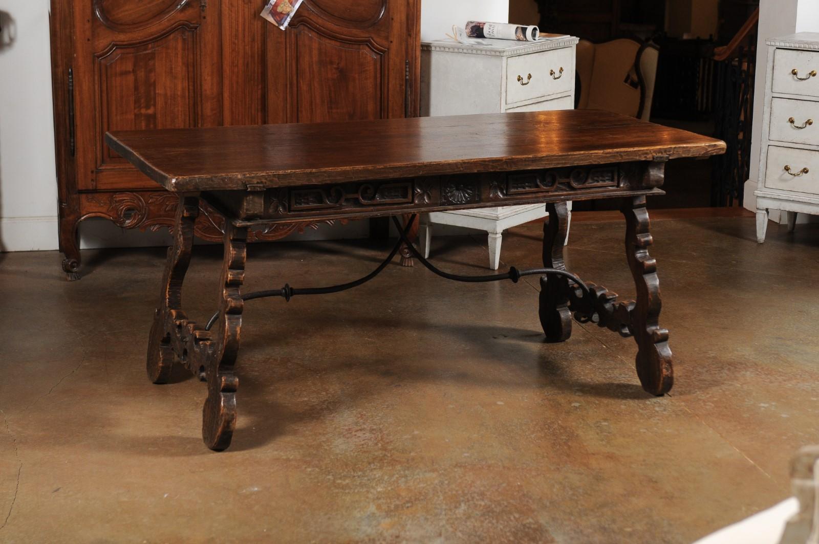 A Spanish Baroque period walnut Fratino table from the mid 18th century, with two carved drawers and wrought-iron stretchers. Created in Spain during the 1750s, this walnut Fratino table features a rectangular top sitting above two carved drawers.